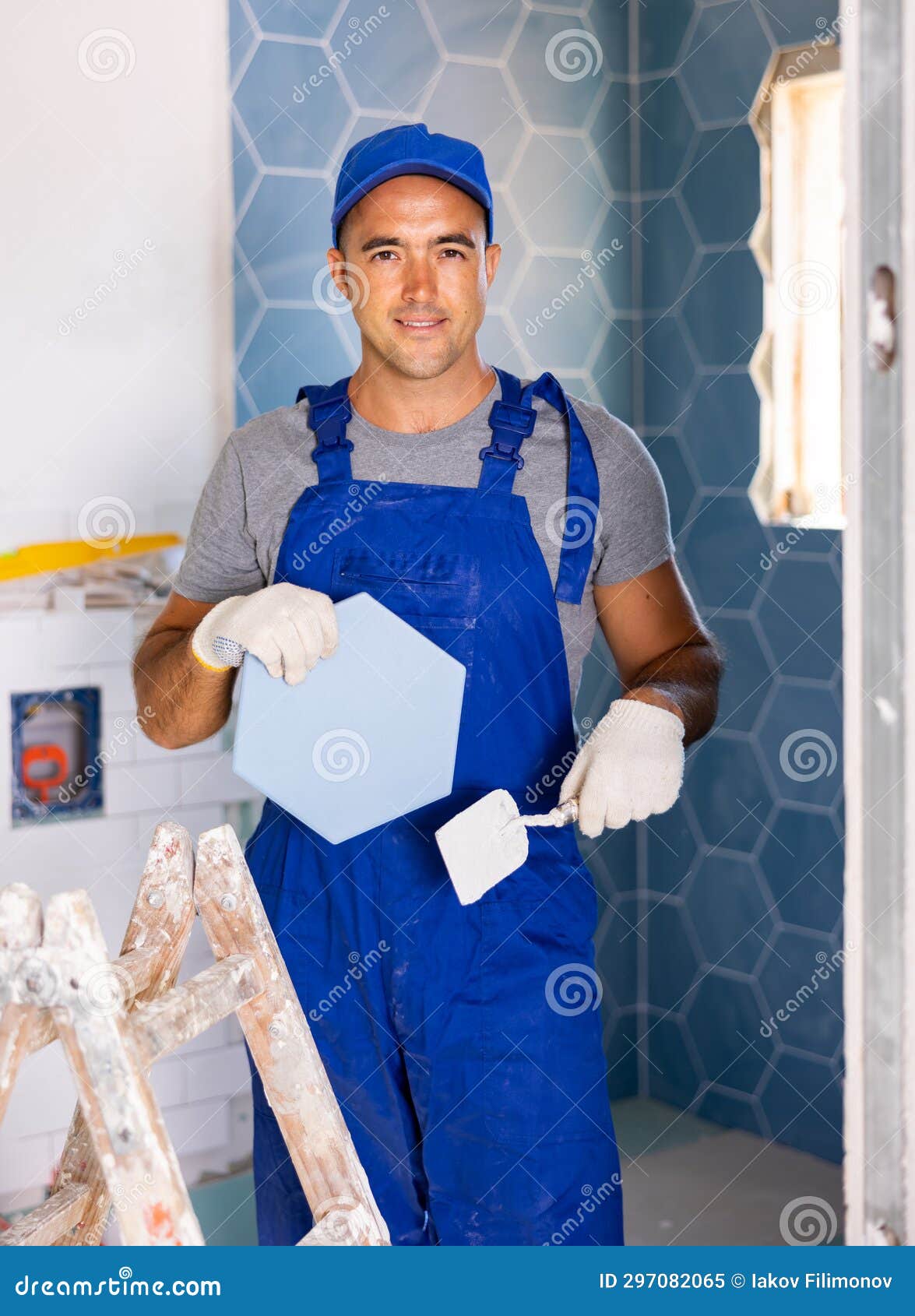 Skilled Builder in Work Clothes Posing with Ceramic Tiles and