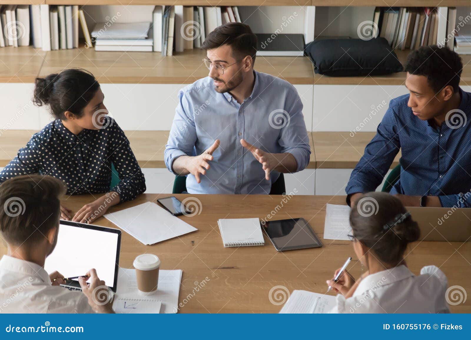 skilled male manager talking to diverse business people at meeting
