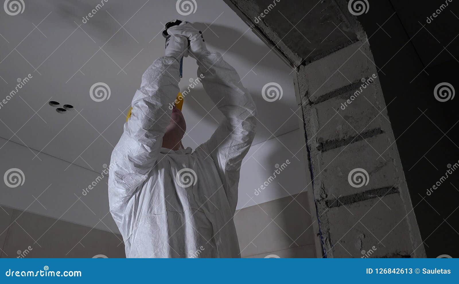 Skilled Worker In Work Wear Making Drywall Ceiling Holes For Light Installation