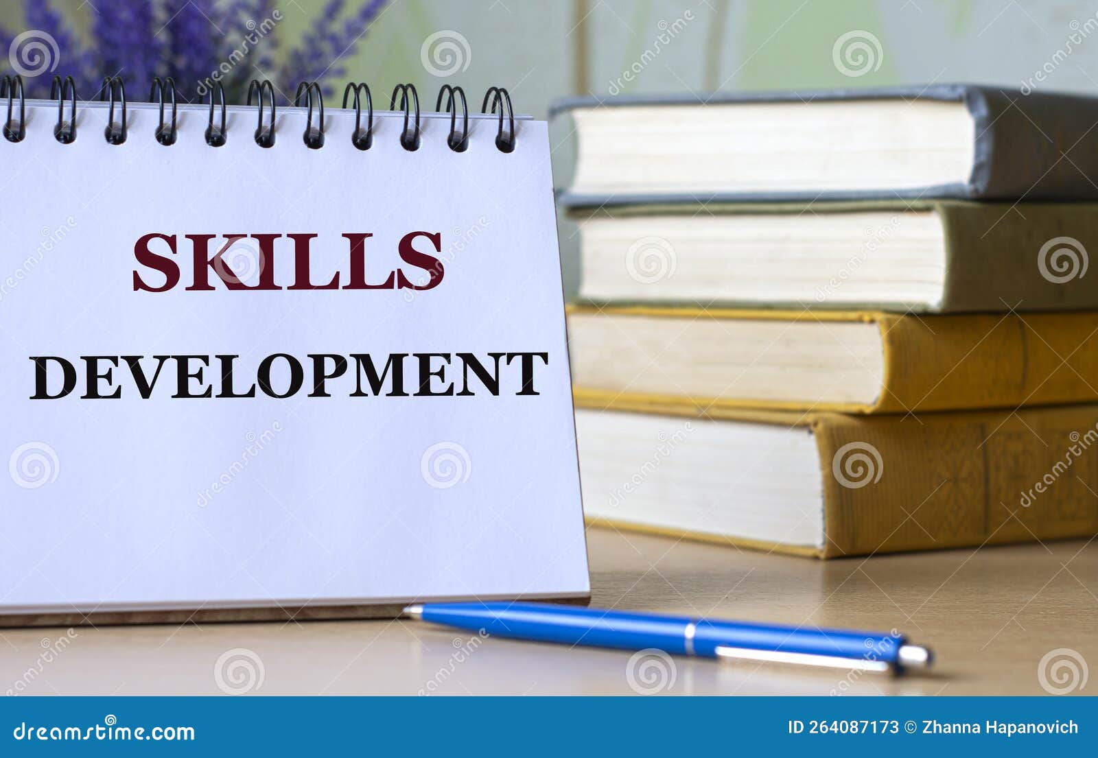 skills development - a word in a notebook against the background of old books with a pen