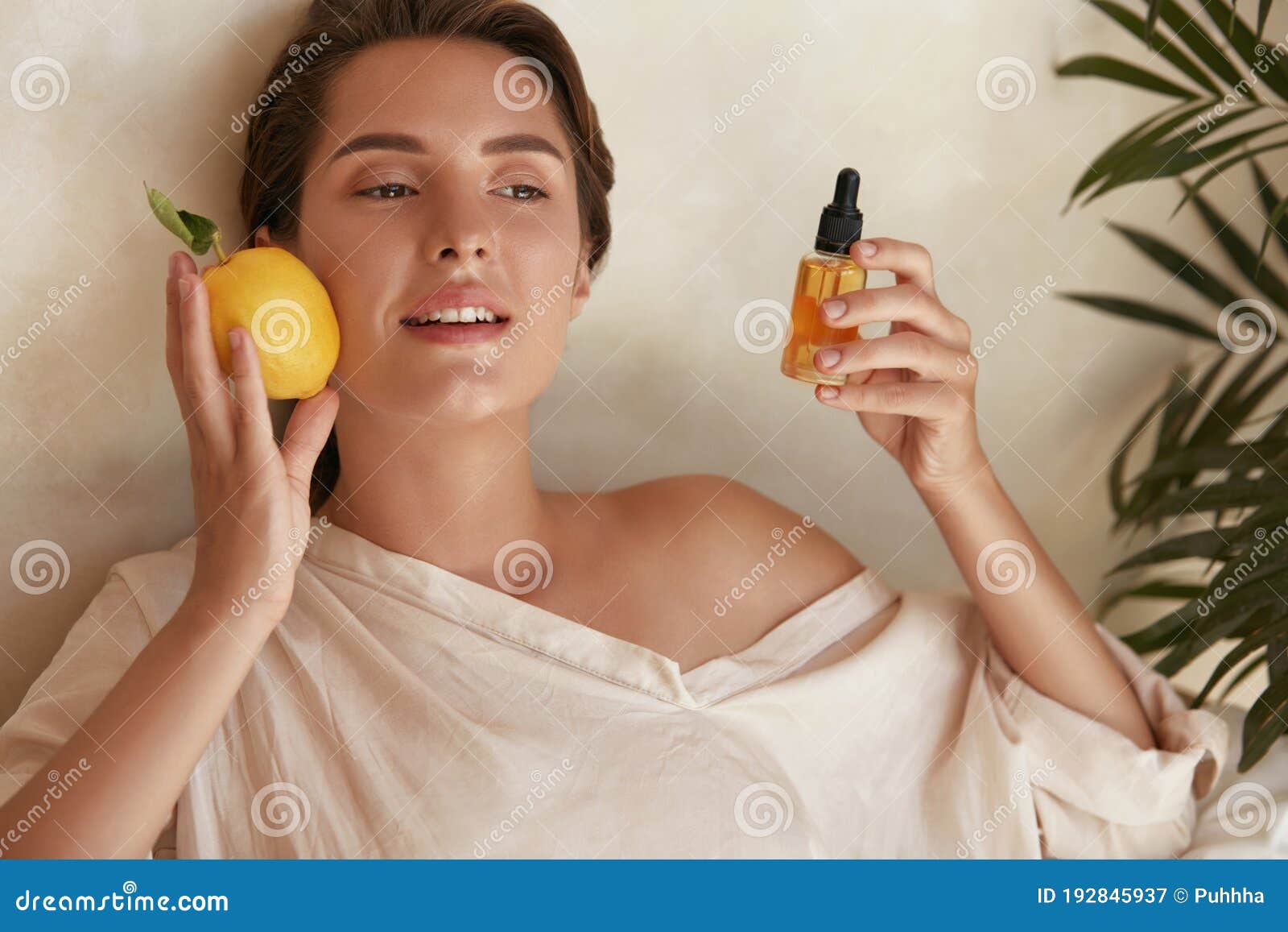 skin care. beauty portrait of woman holding lemon and bottle near face. natural cosmetic product for hydrated derma.