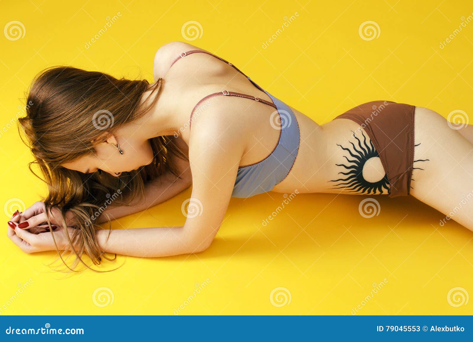 Skinny Girl on a Yellow Background in Beautiful Lingerie Stock