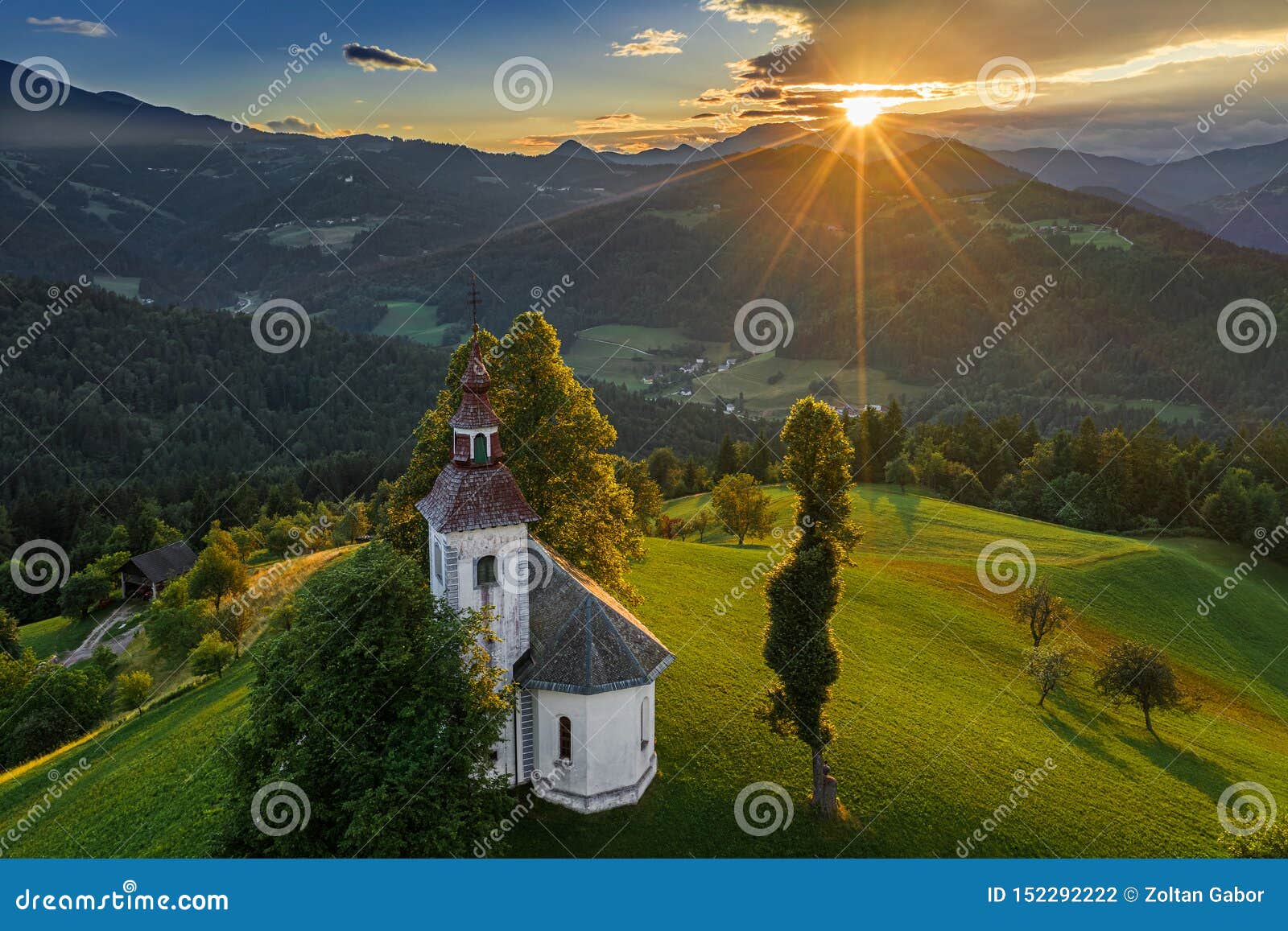 skofja loka, slovenia - aerial view of the beautiful hilltop sveti tomaz saint thomas church with an amazing sunset
