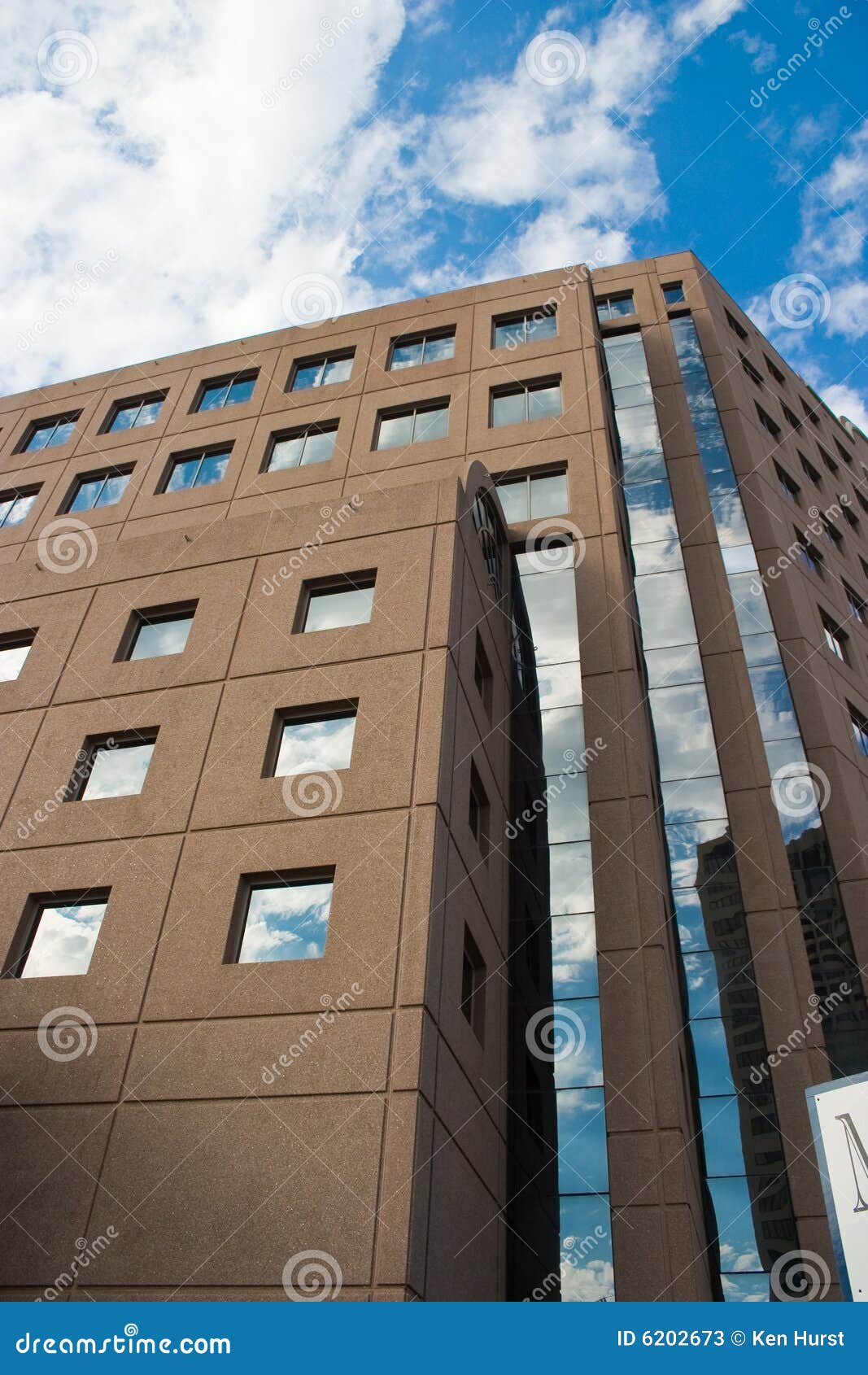 Sky Reflections. Tall building reflects a deep blue sky in its simple square windows.