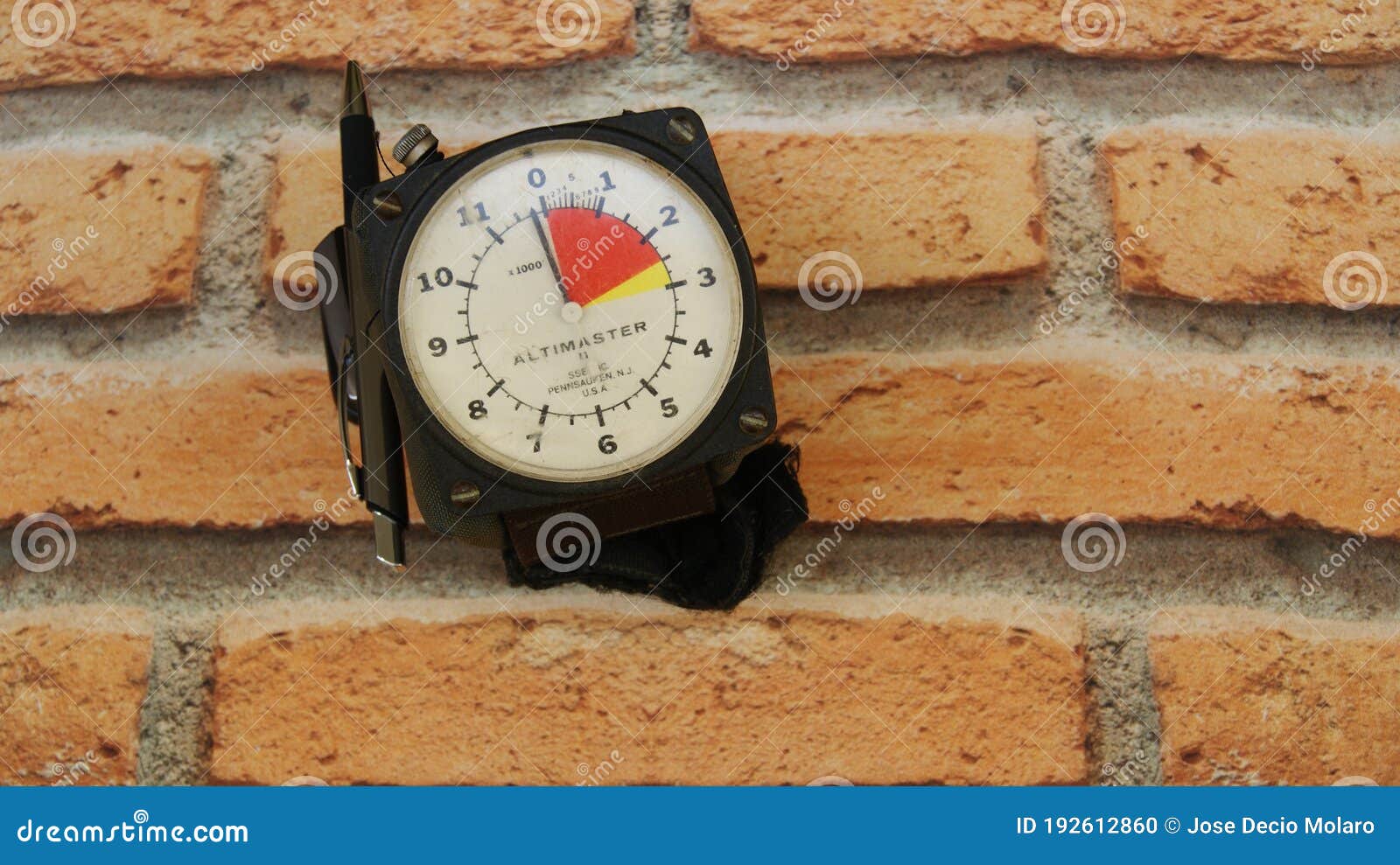 skydiving altimeter, used by skydiver, with a pen for annotation, brick background, top view, zoom photo