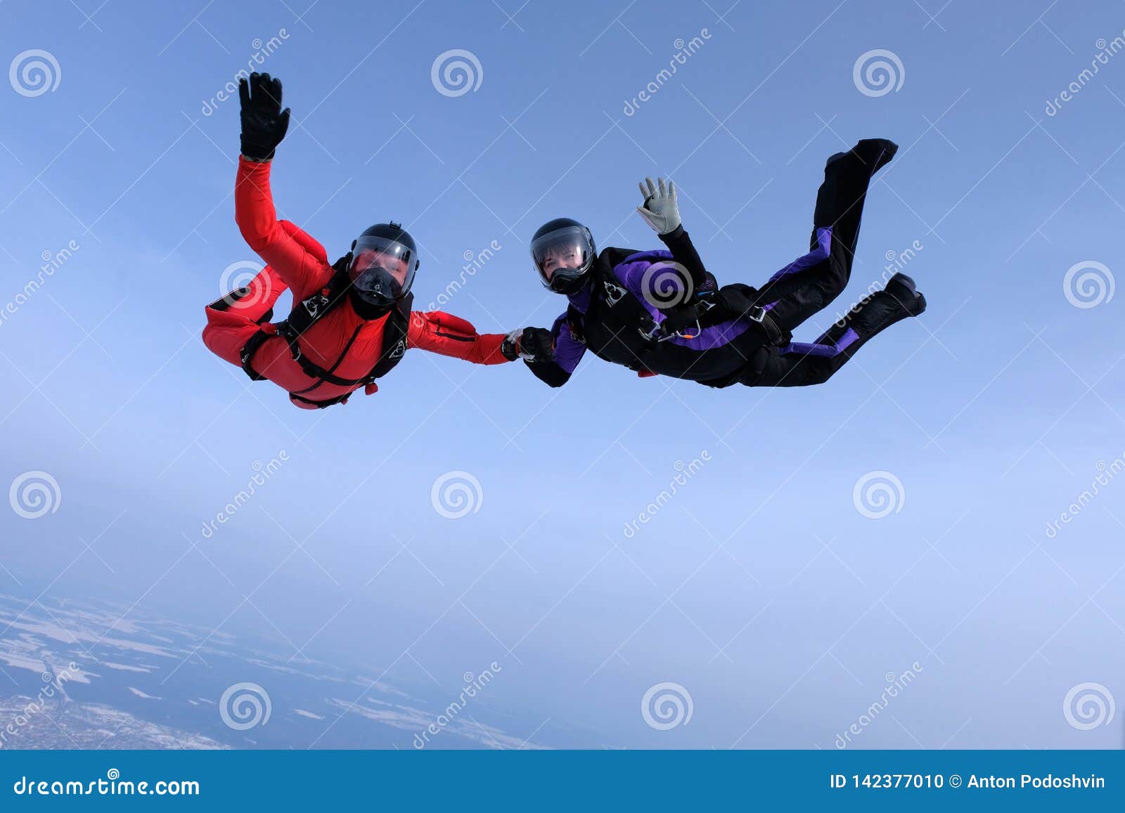 skydiving in the blue sky.. two skydivers send hello.