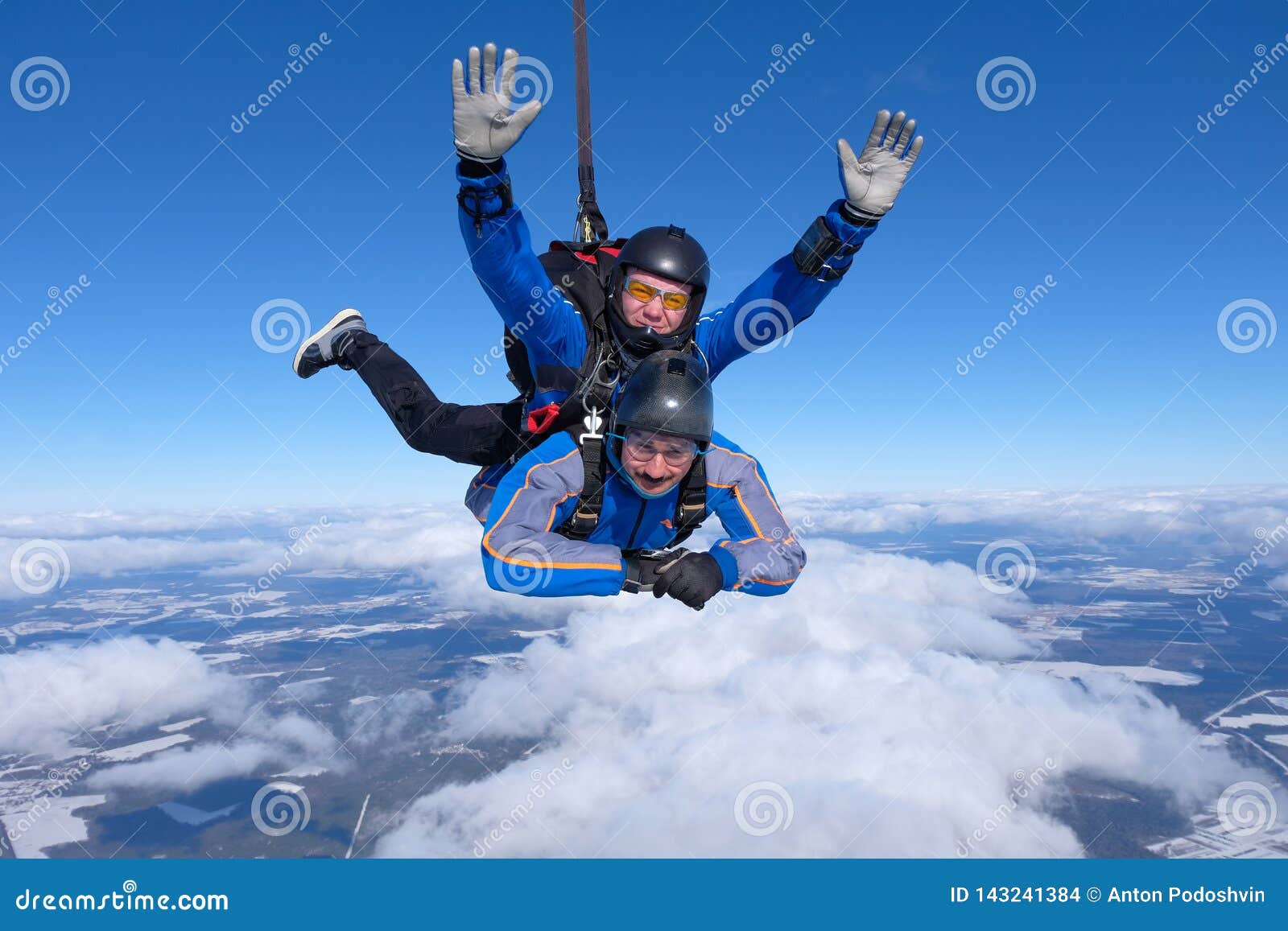 tandem skydiving. two guys are in the blue sky.