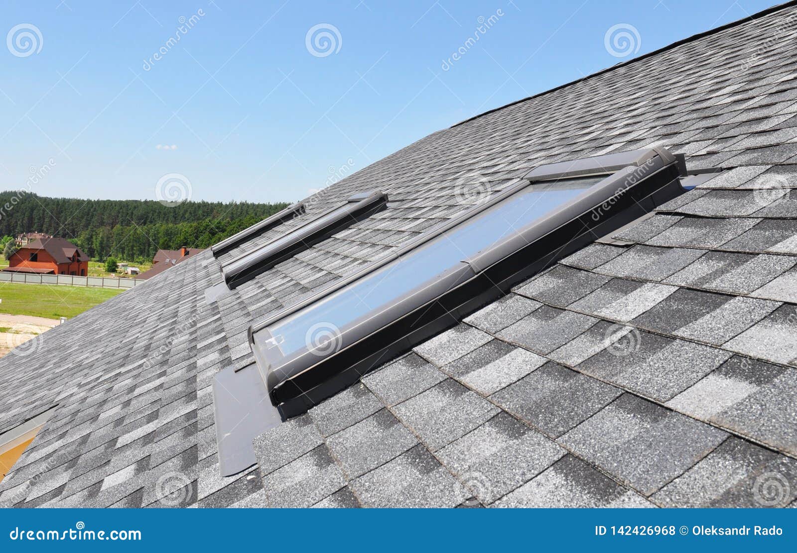 skylights windows on modern house roof top.  attic skylight windows on asphalt shingles roof