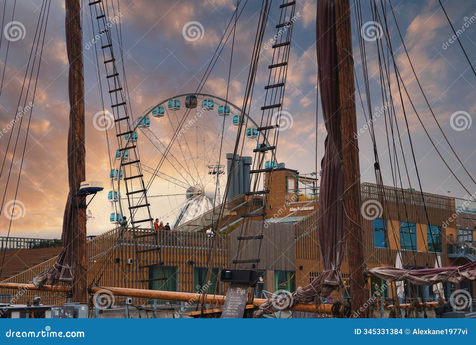 skywheel helsinki and ship rigging at sunset in city center