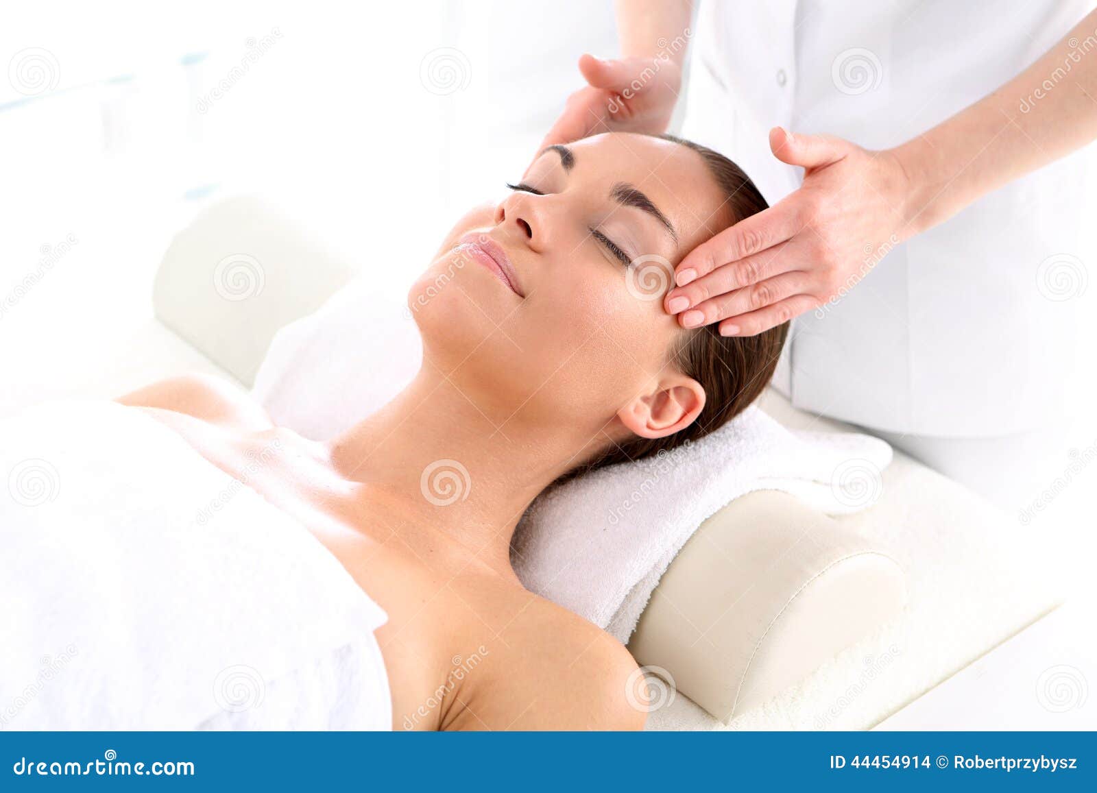Skönhetsmedel - kvinna på massagen. Attraktiv brunettkvinna i brunnsortsalong