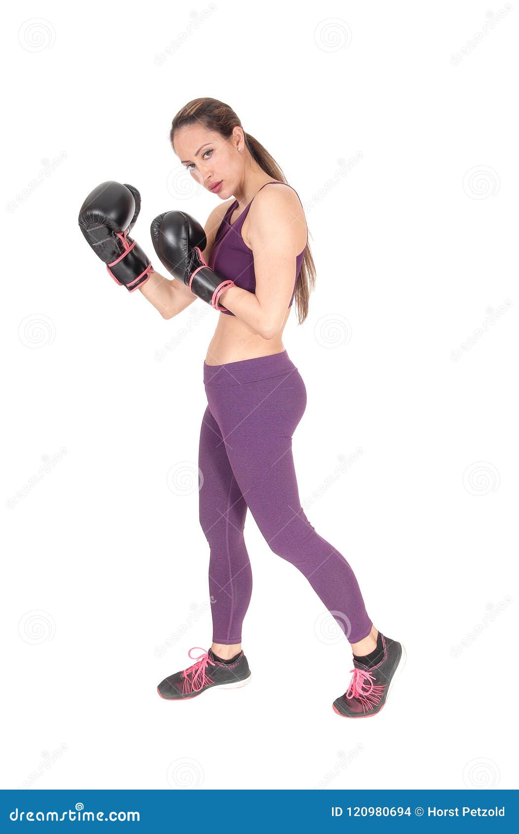 Slankt kvinnaanseende i genomköraredräkt och boxning. En full kroppbild av en kvinnaboxning och i genomkörare utrustar anseendet som isoleras för vit bakgrund