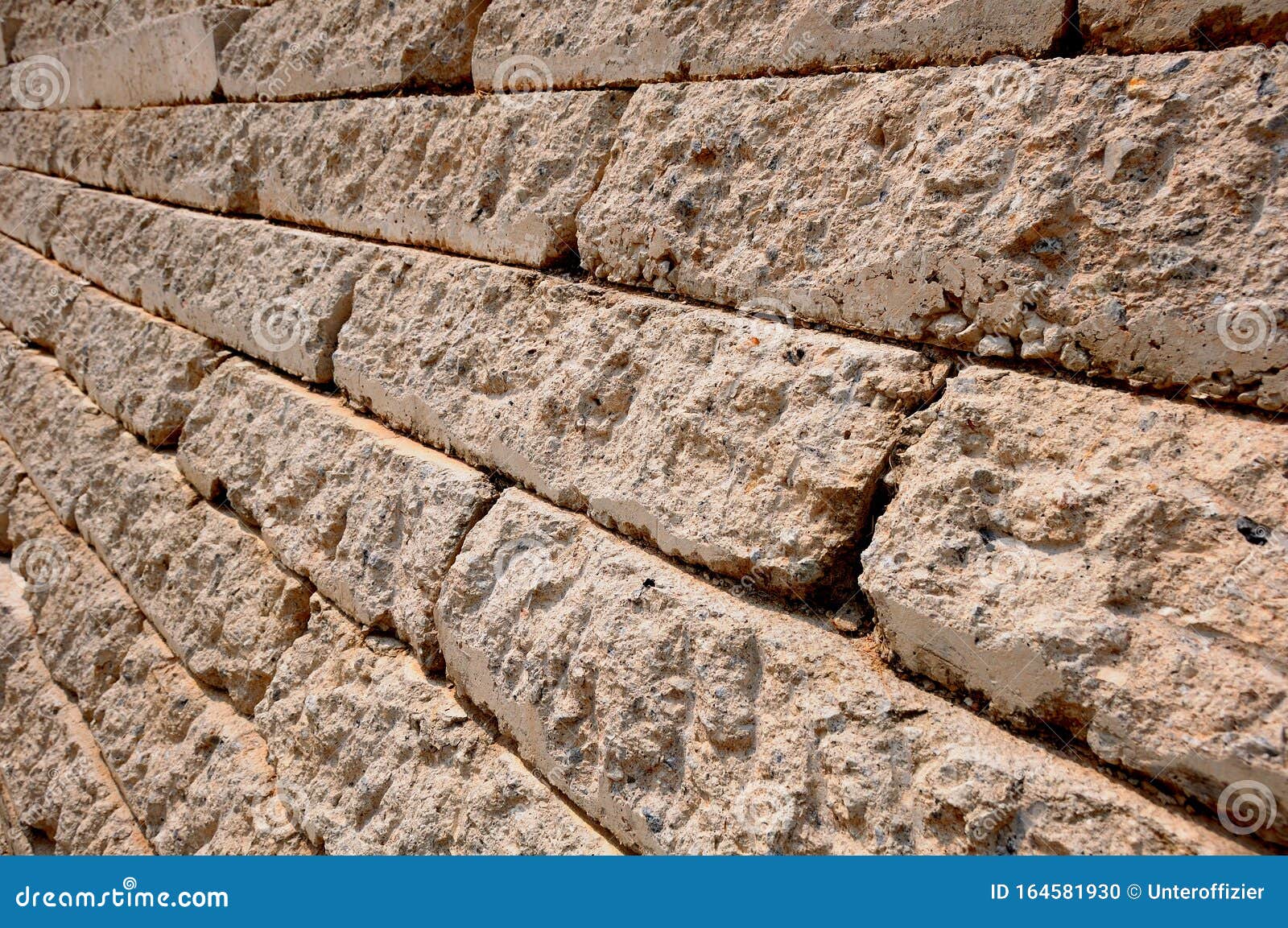 a slanting side wall made of weather washed brown hard rough bricks