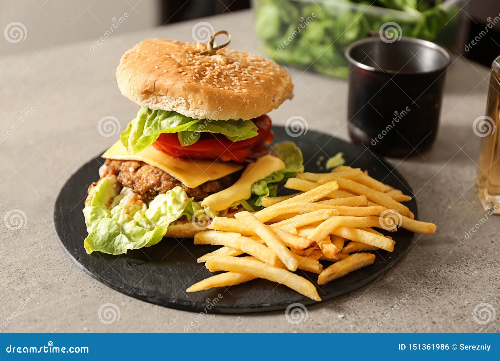 Slate Plate With Tasty Burger And French Fries On Table Stock Photo