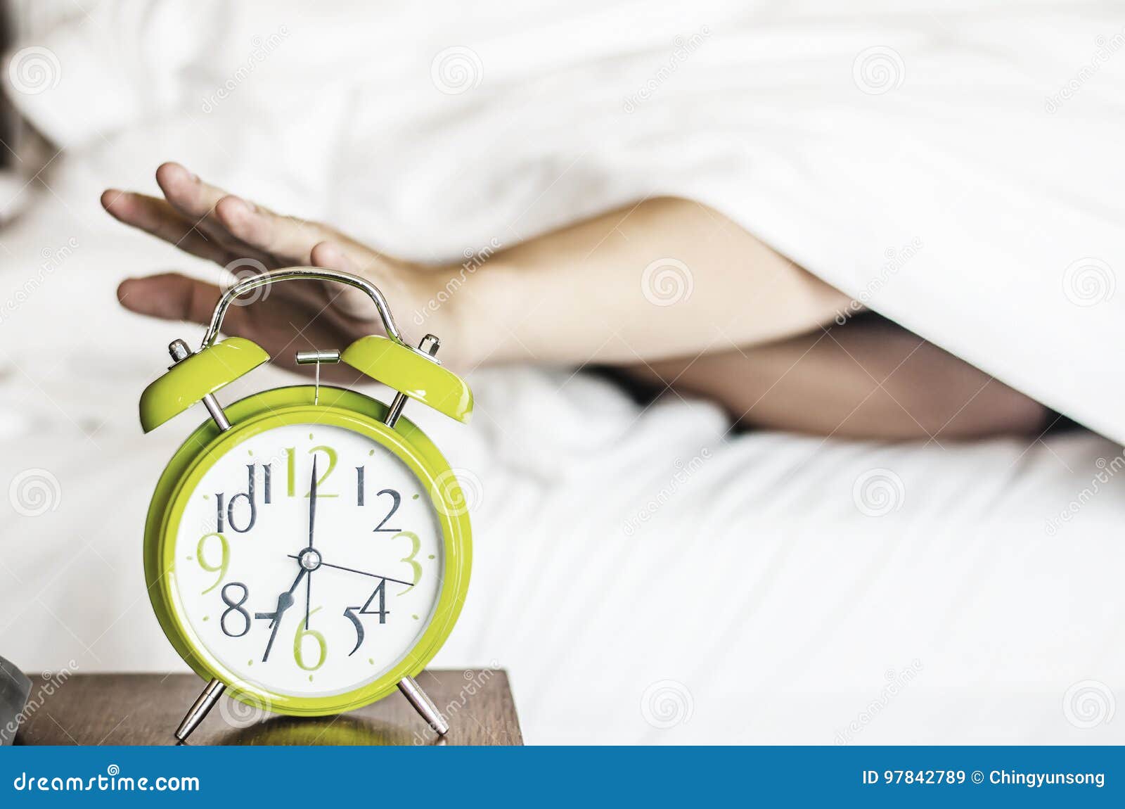 sleeping asian young male disturbed by alarm clock early morning
