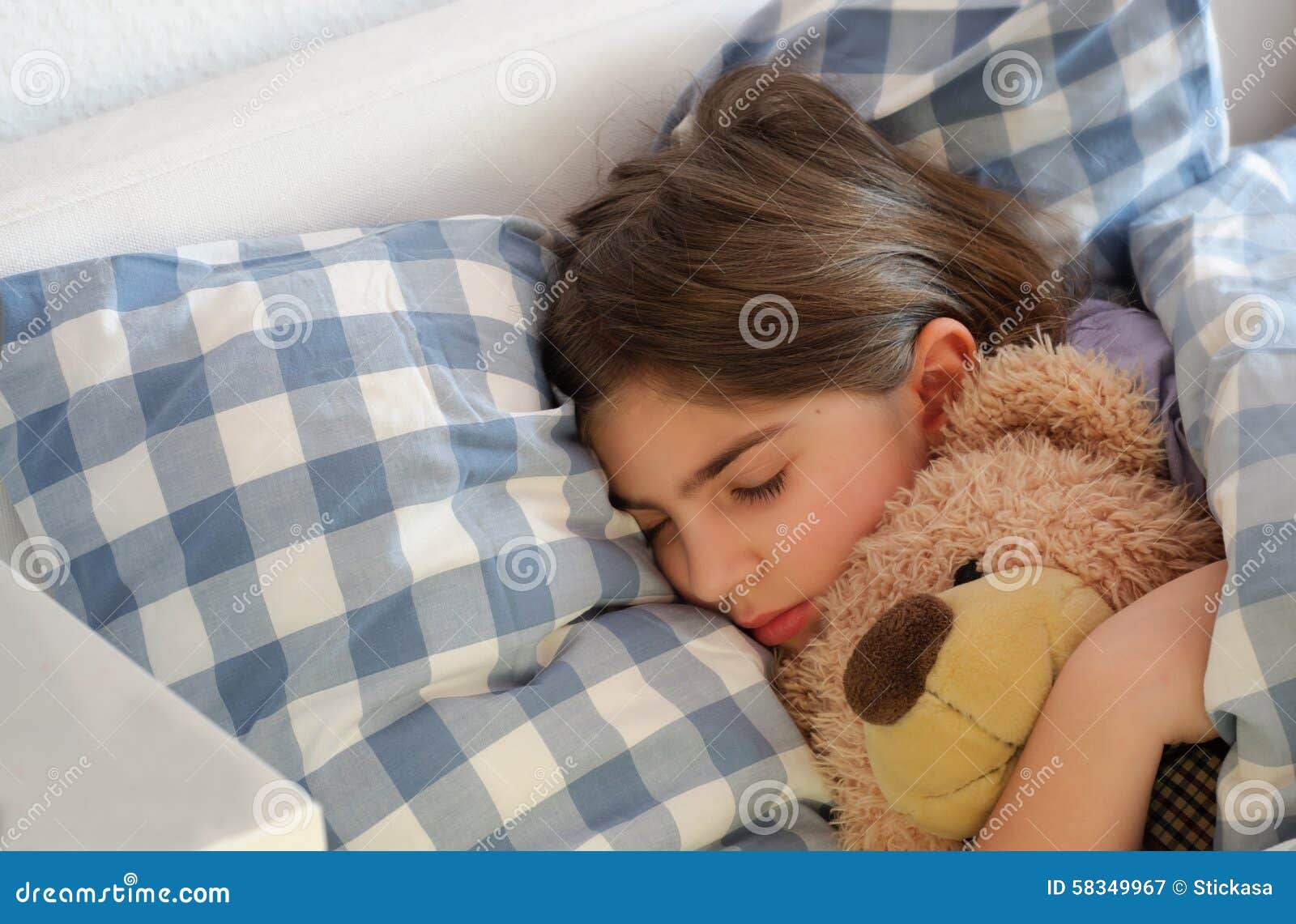 girl cuddling teddy bear