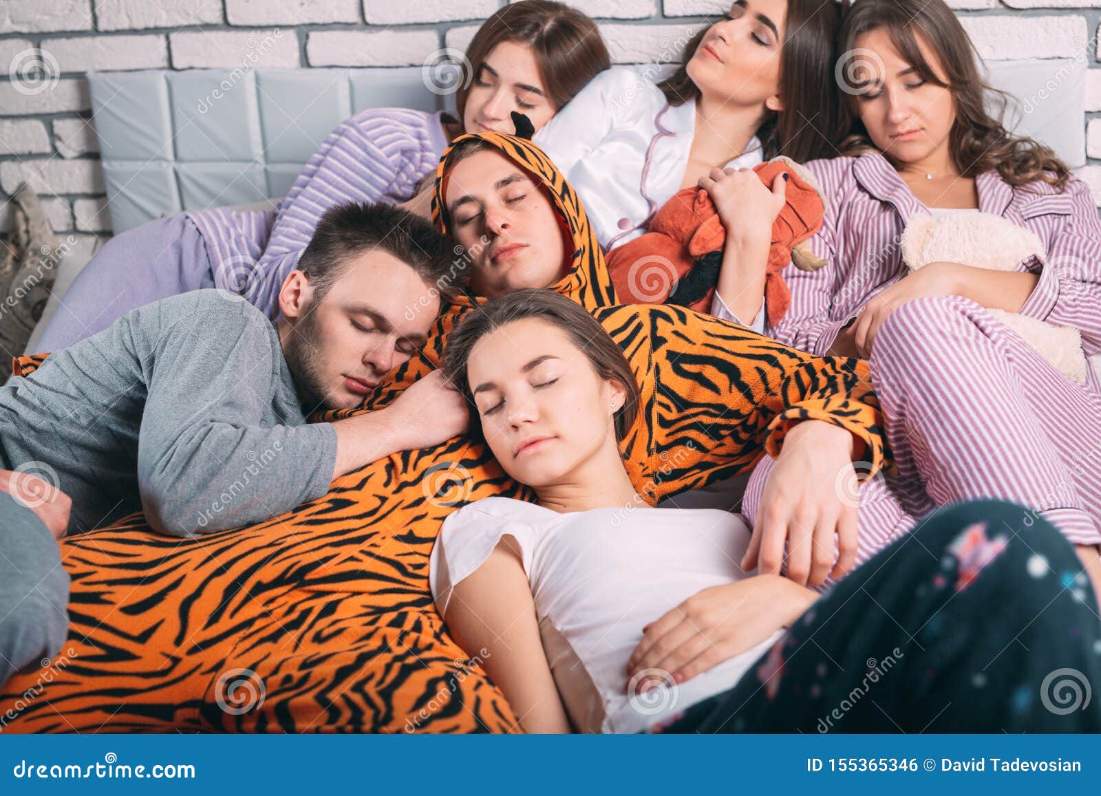 Sleeping Group of Young People on the Bed. Stock Photo Image of