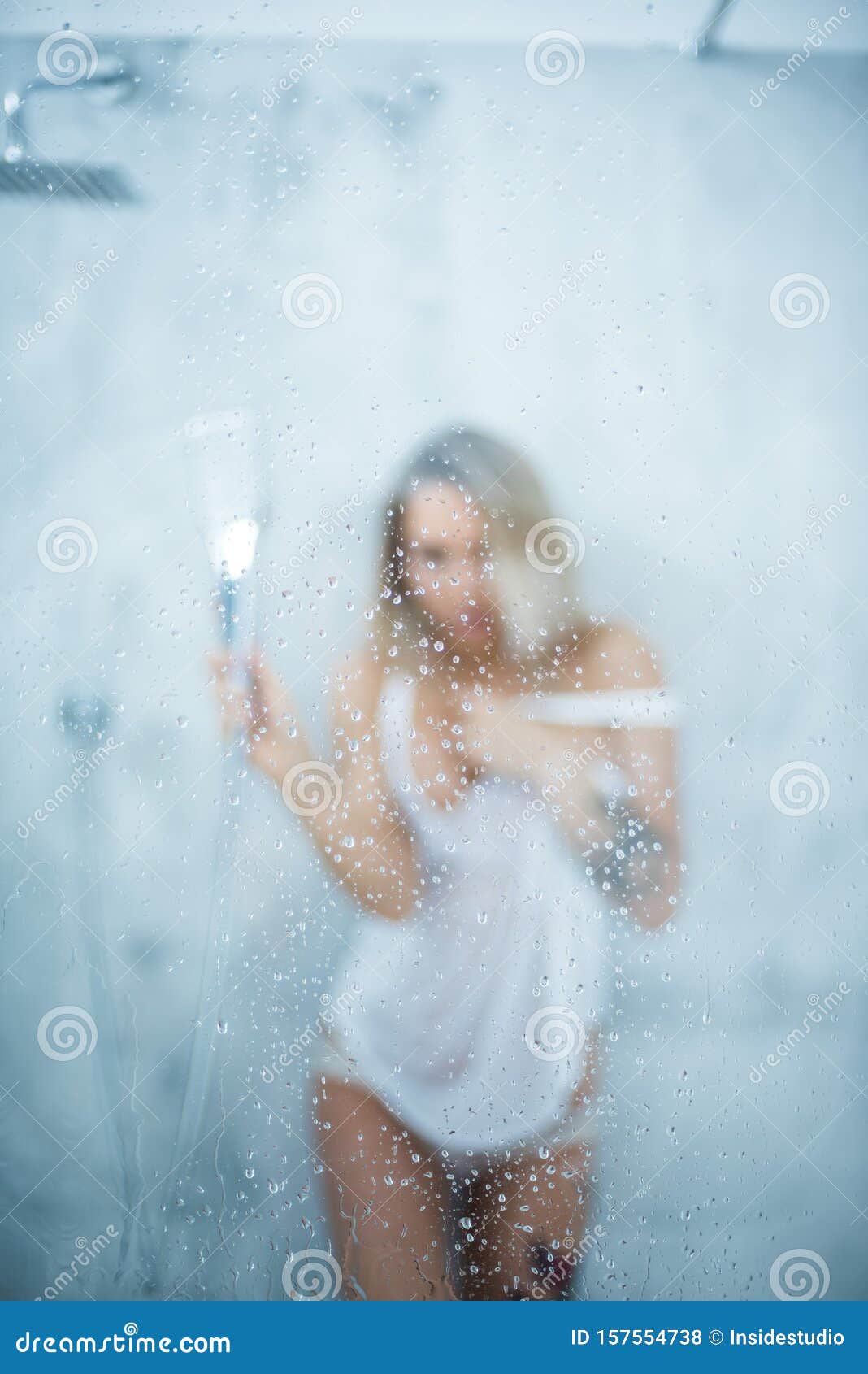 A Slender Girl In A White Wet T Shirt Takes A Shower Pours Water