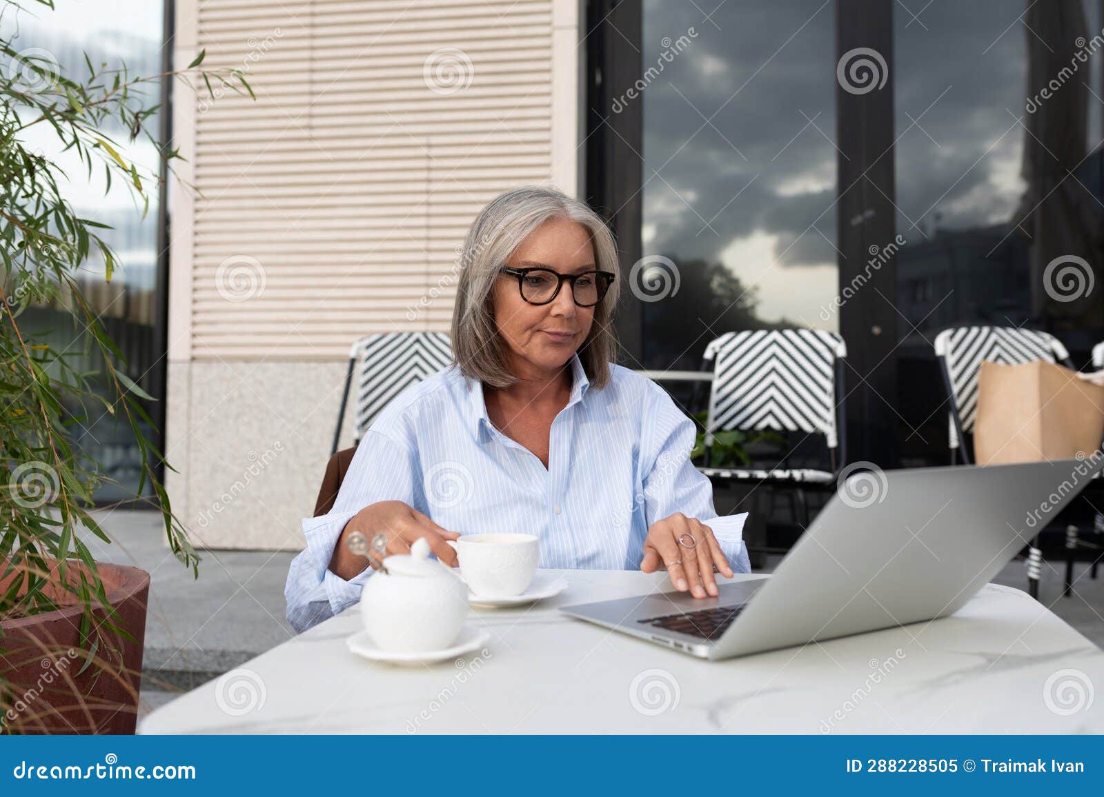 A Slender Gray Haired Woman Of Mature Years Dressed In A Light Blue