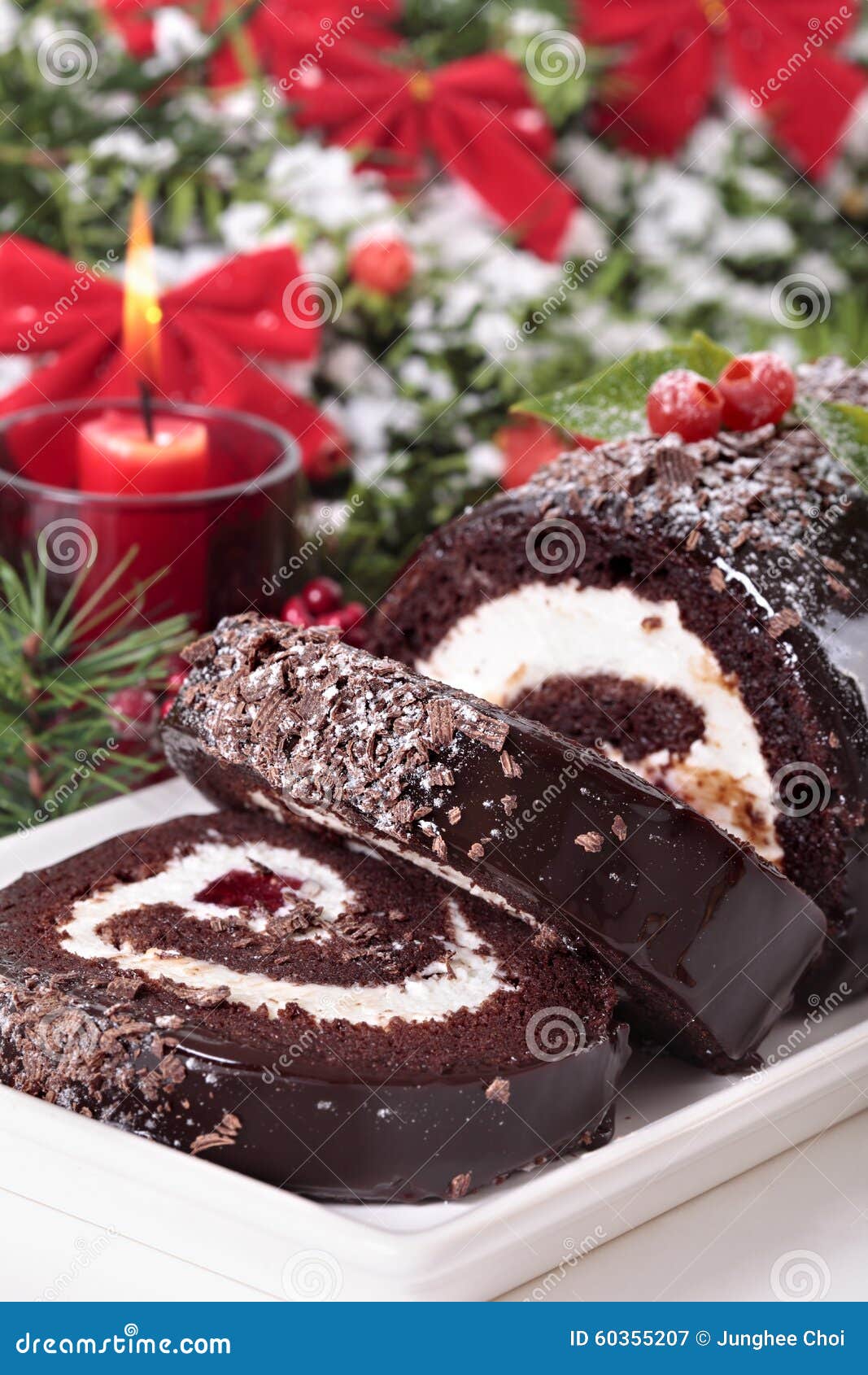 Slice of Christmas Yule Log Cake on Plate with Candle Stock Image