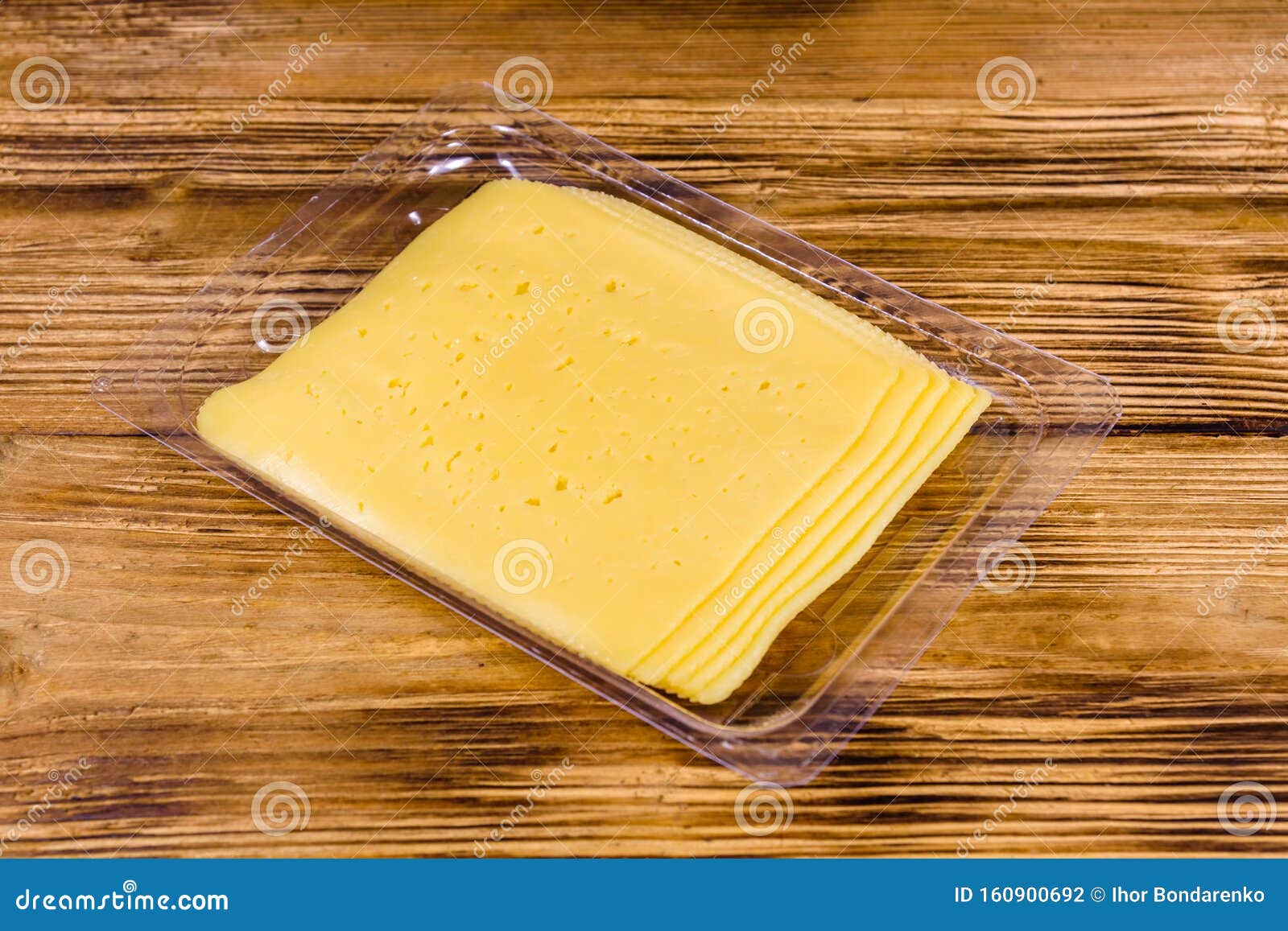 Sliced Cheese and Parsley in Plastic Container on Wooden Table Stock