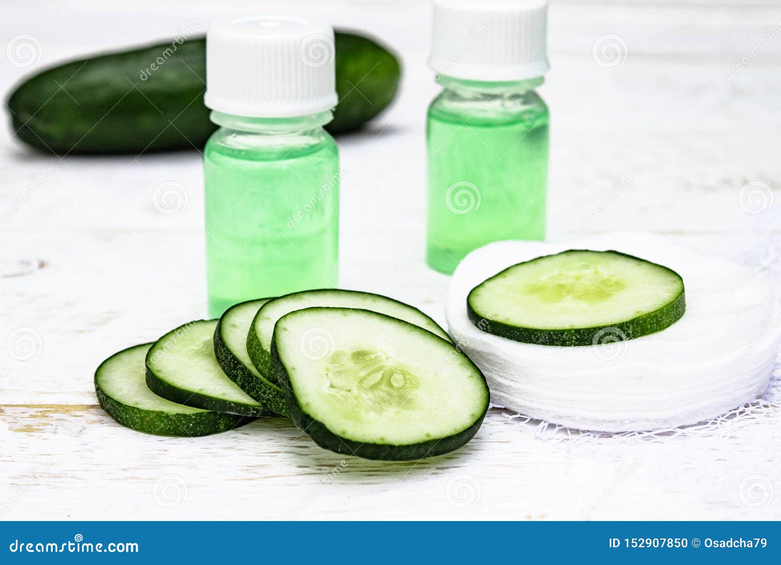 sliced cucumber and a bottle of cucumber extract. liquid cosmetics for skin care