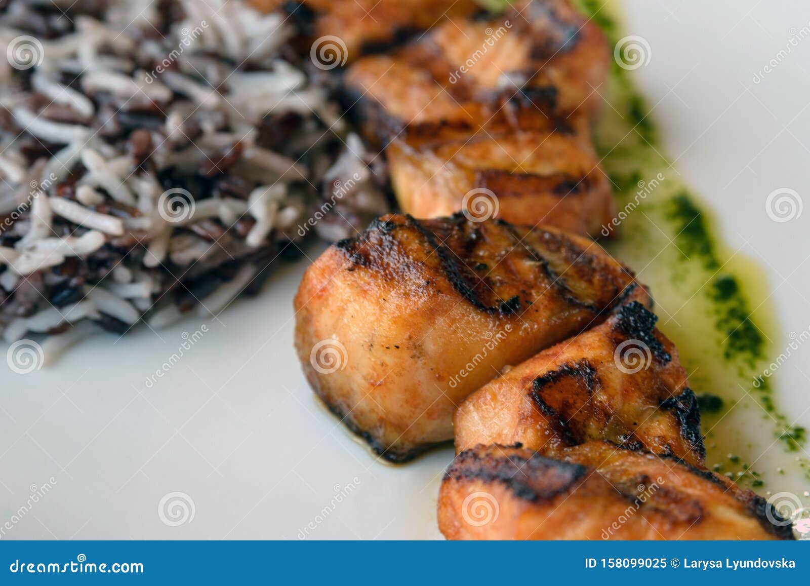 Sliced Fried Fish and Wild Rice on a White Background. Sturgeon Kebab