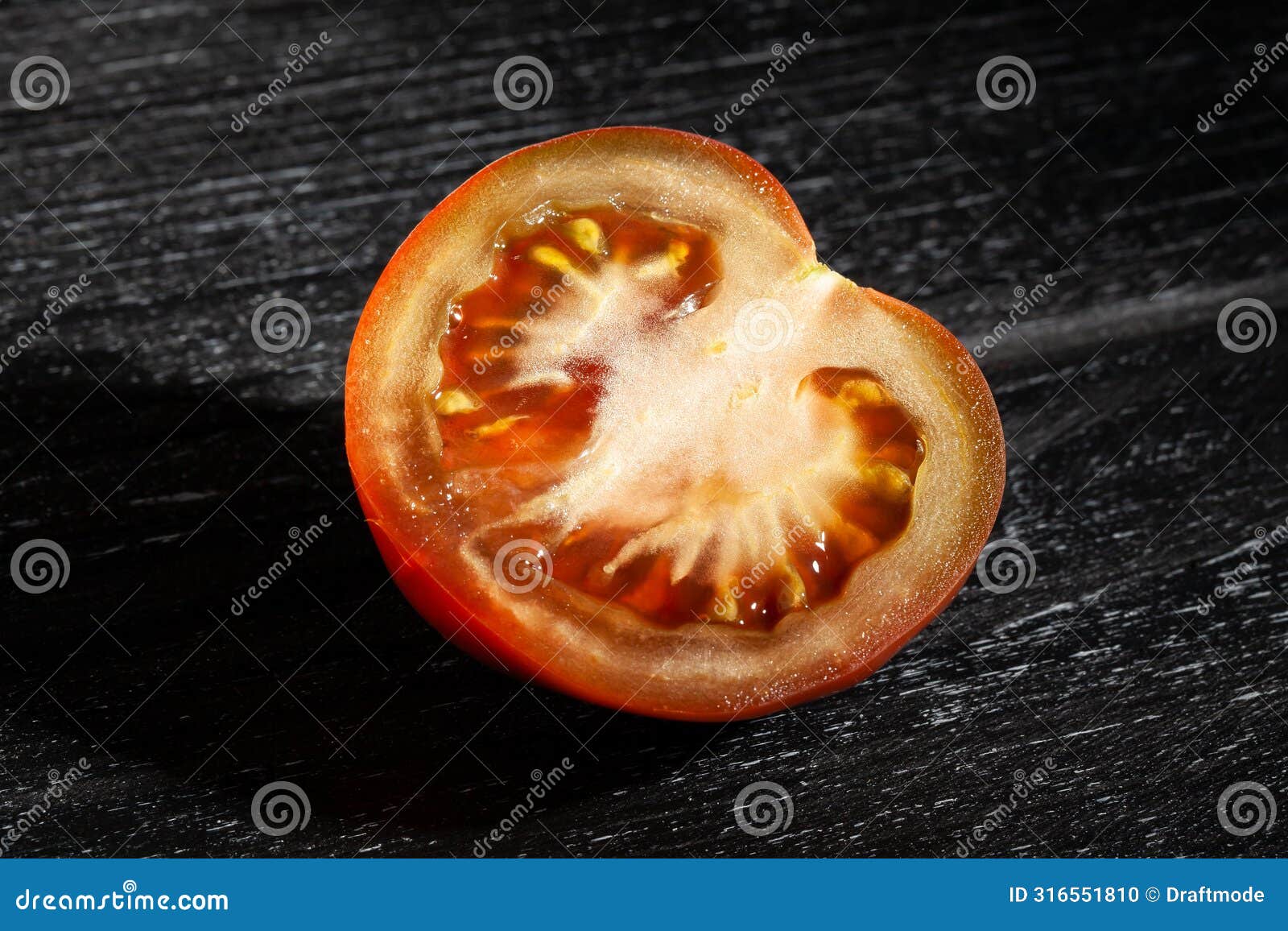 sliced kumato tomato on black wood