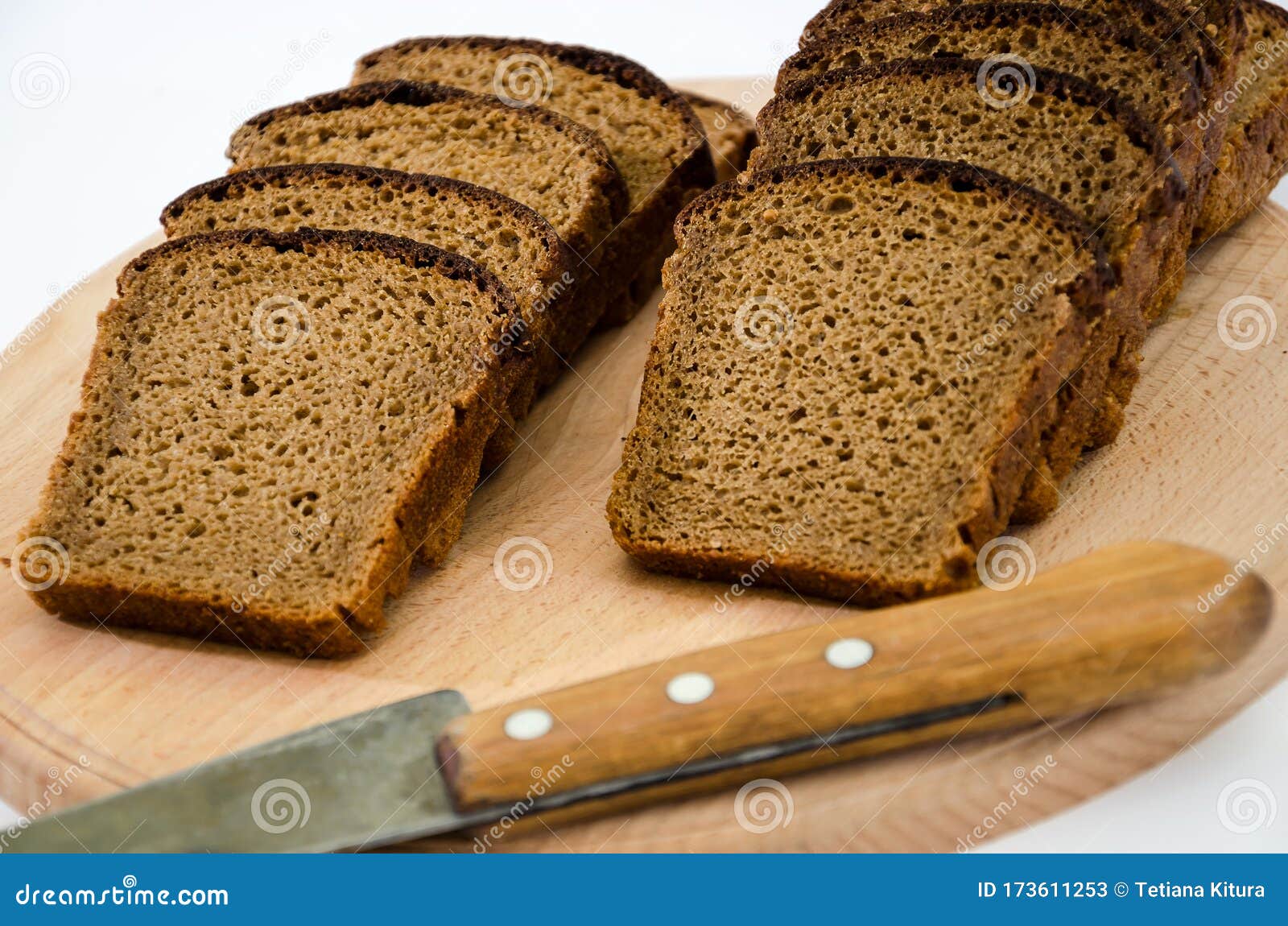 Sliced Rye Bread with Knife on Cutting Board. Isolated on White. Stock