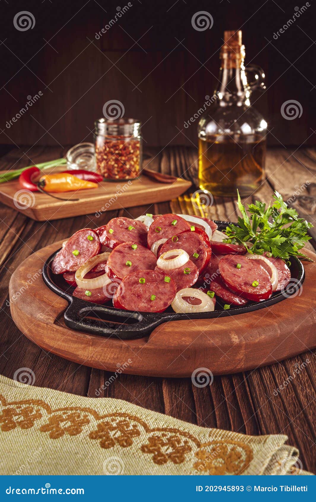 sliced smoked calabrese sausage with onion in a wooden background - brazilian appetizer