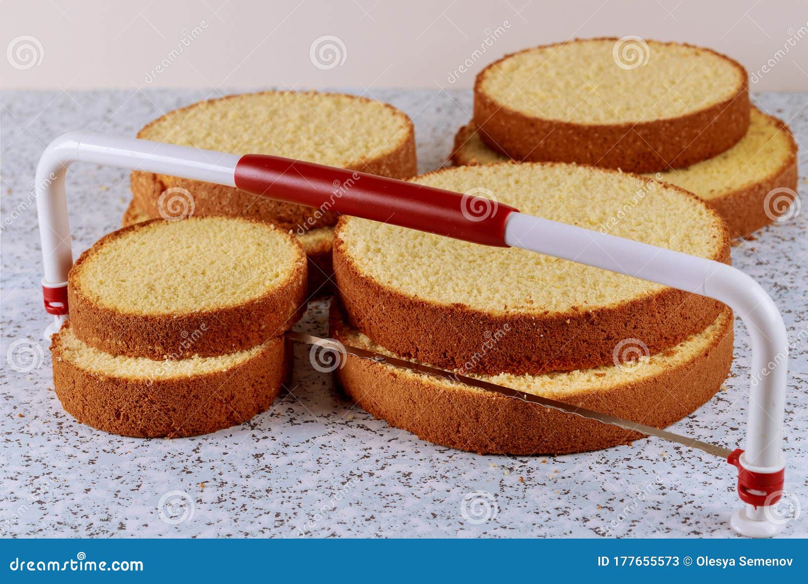 sliced sponge cake with leveler on table for making wedding cake