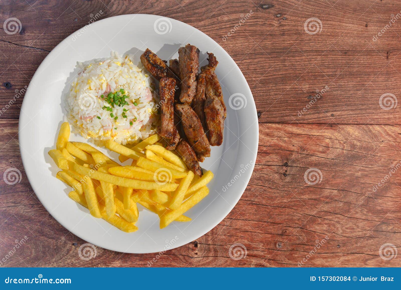 sliced steak with rice and fries sides