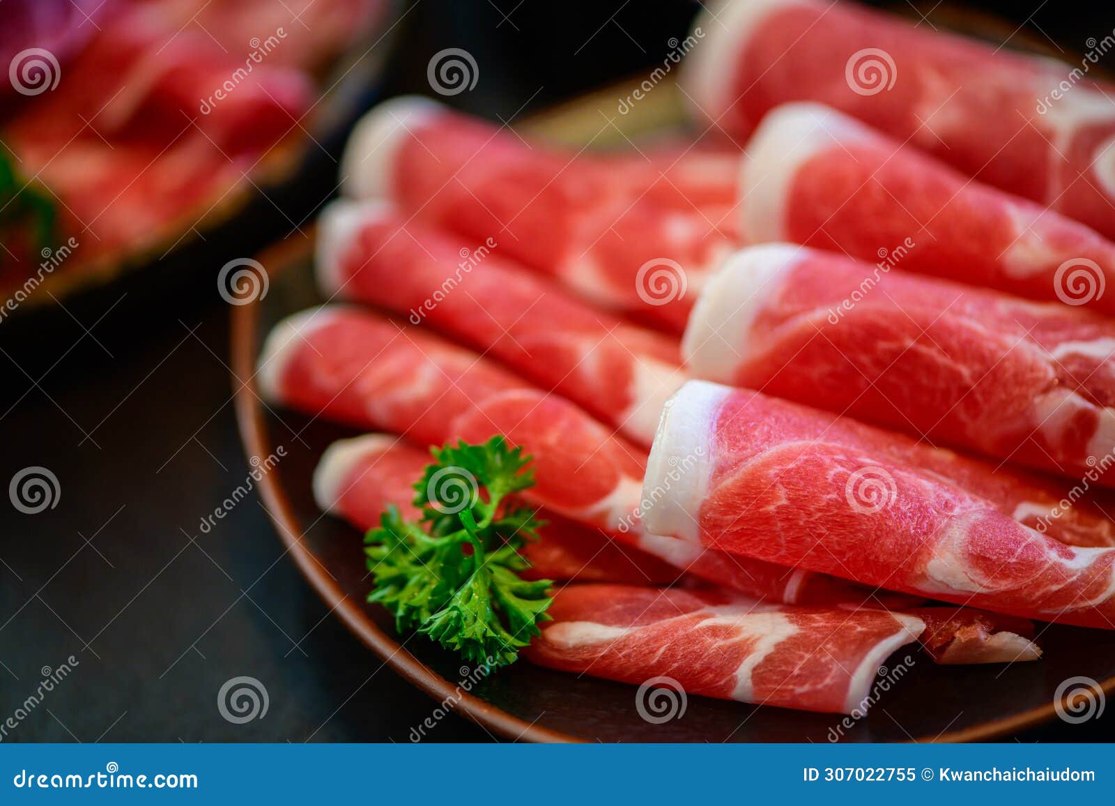 sliced topside wagyu beef for yakiniku on plate on black background, premium japanese meat