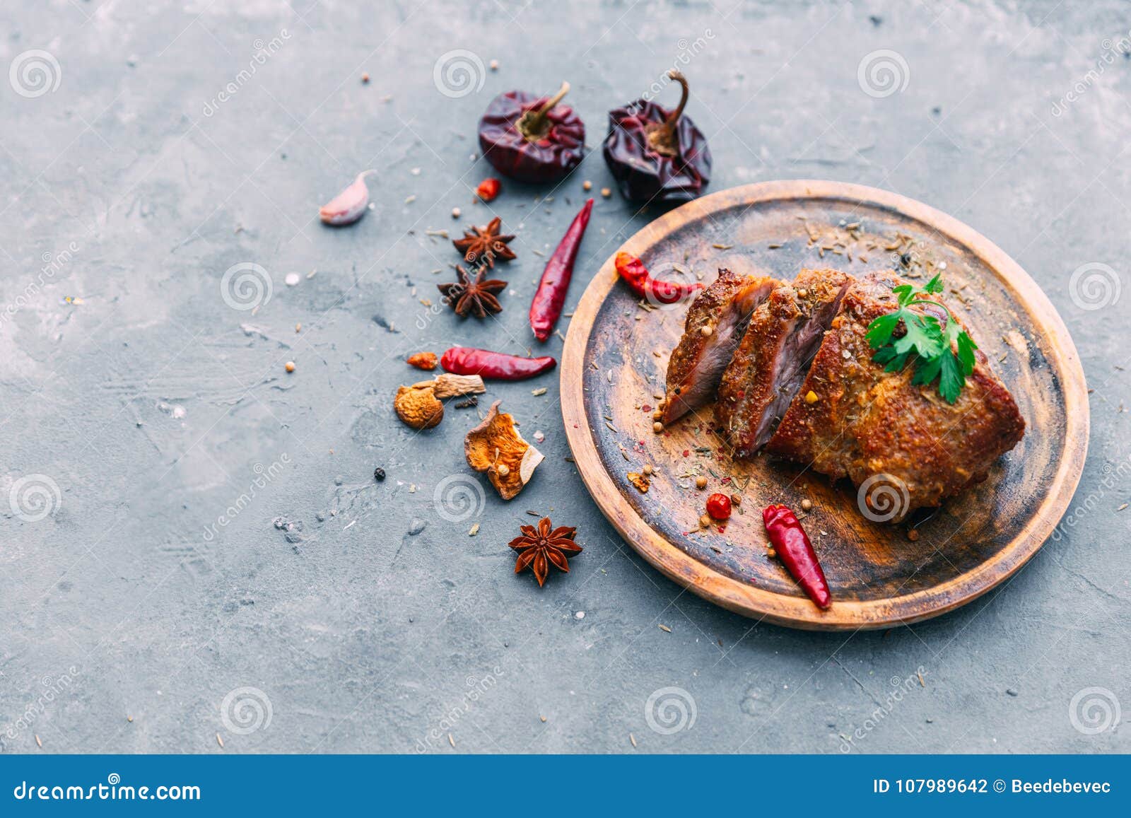 slices of beef steak with spices on blue table