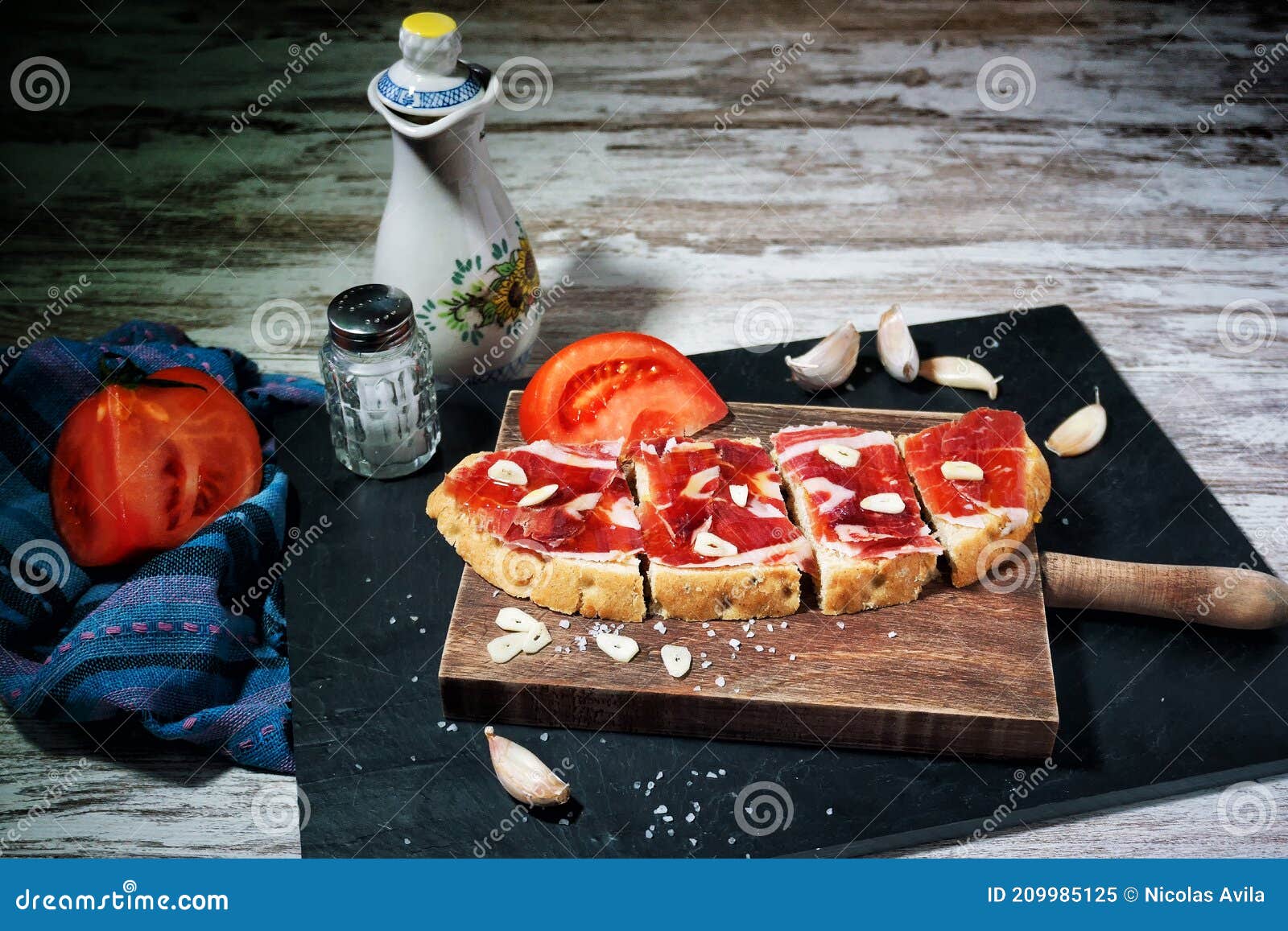 slices of bread with ham, oil, tomato and garlic