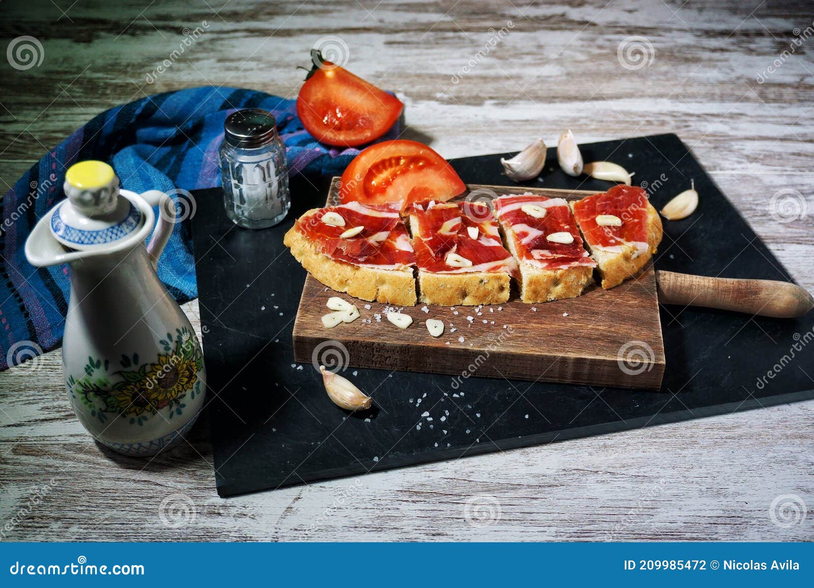 slices of bread with ham, oil, tomato and garlic