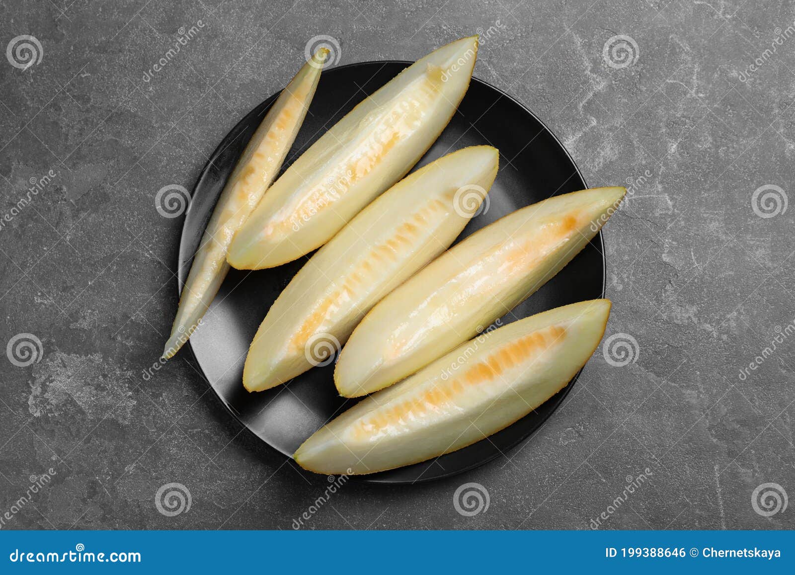 slices of delicious melon on black table, top view