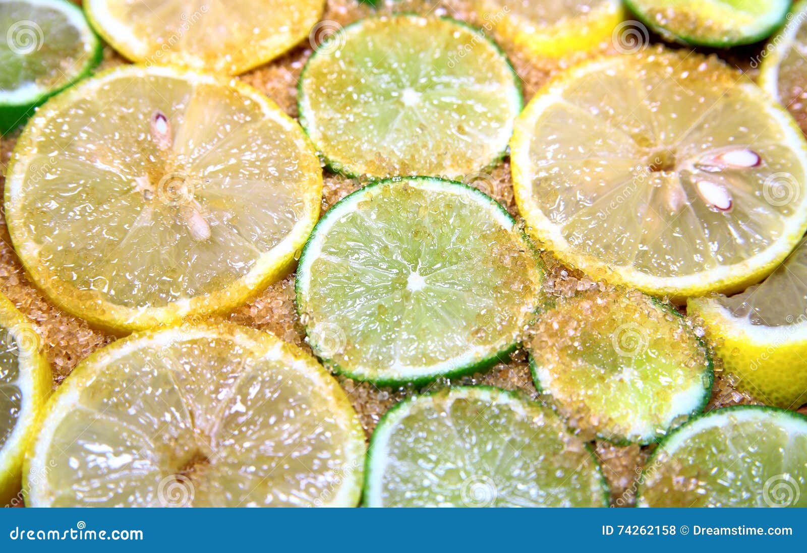 View on slices of limes and lemons mixed with cane sugar placed flat on the ground