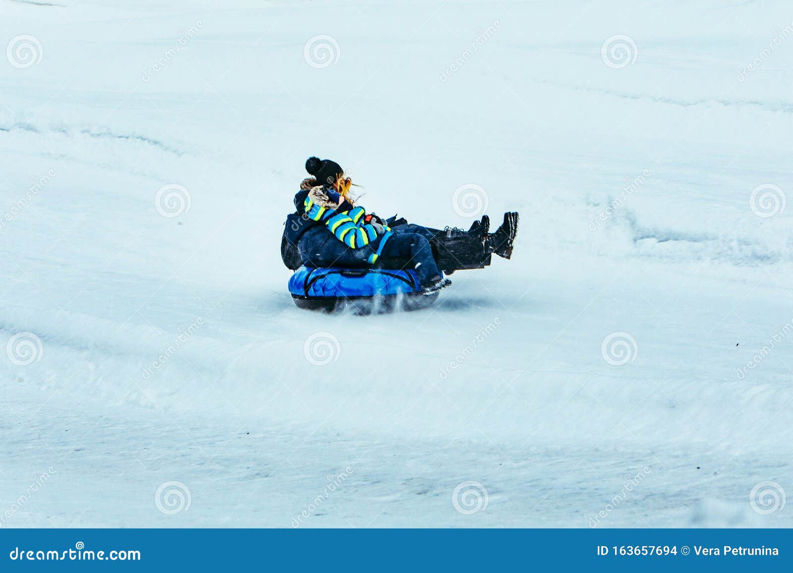 Man skier in black ski suit and goggles skiing downhill trough