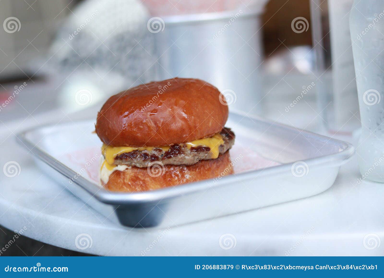 slighty overcooked juicy hamburger bun and cheese melting from the sides of the burger