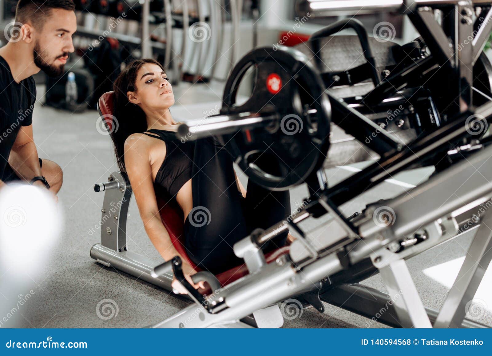 Slim Dark-haired Girl Dressed in Black Sport Clothes is Lifting Weights ...