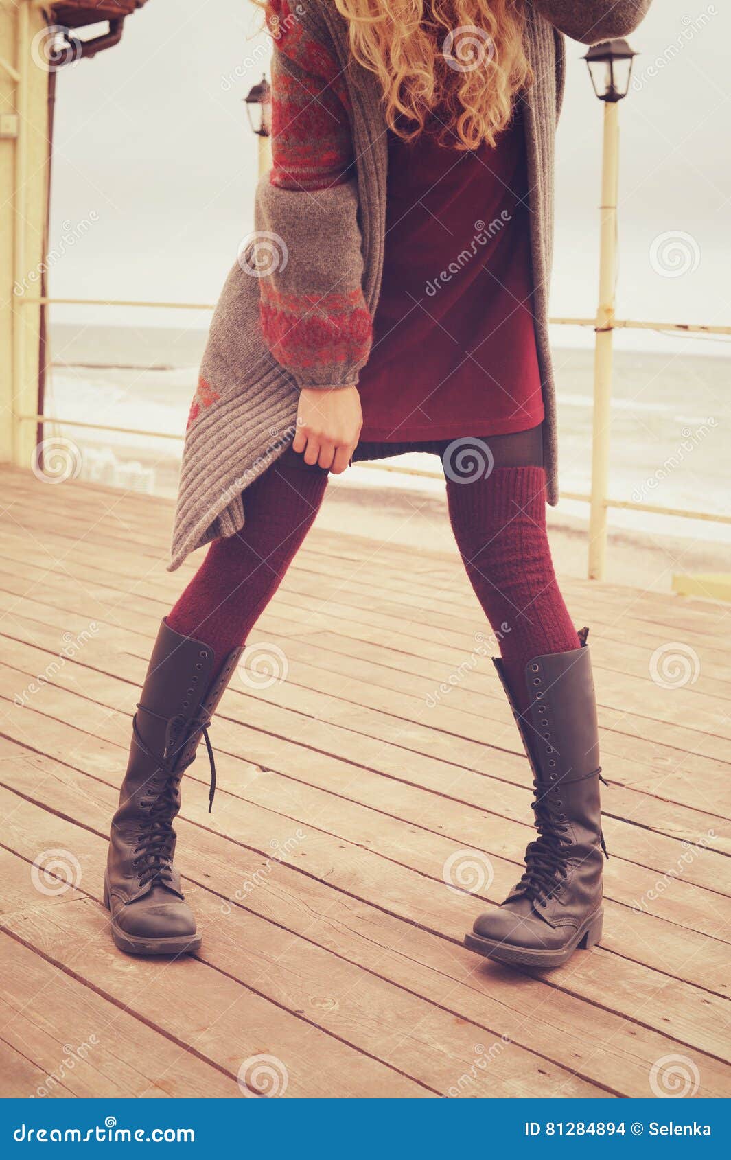 slim female legs dressed in leather shoes with laces and knitted