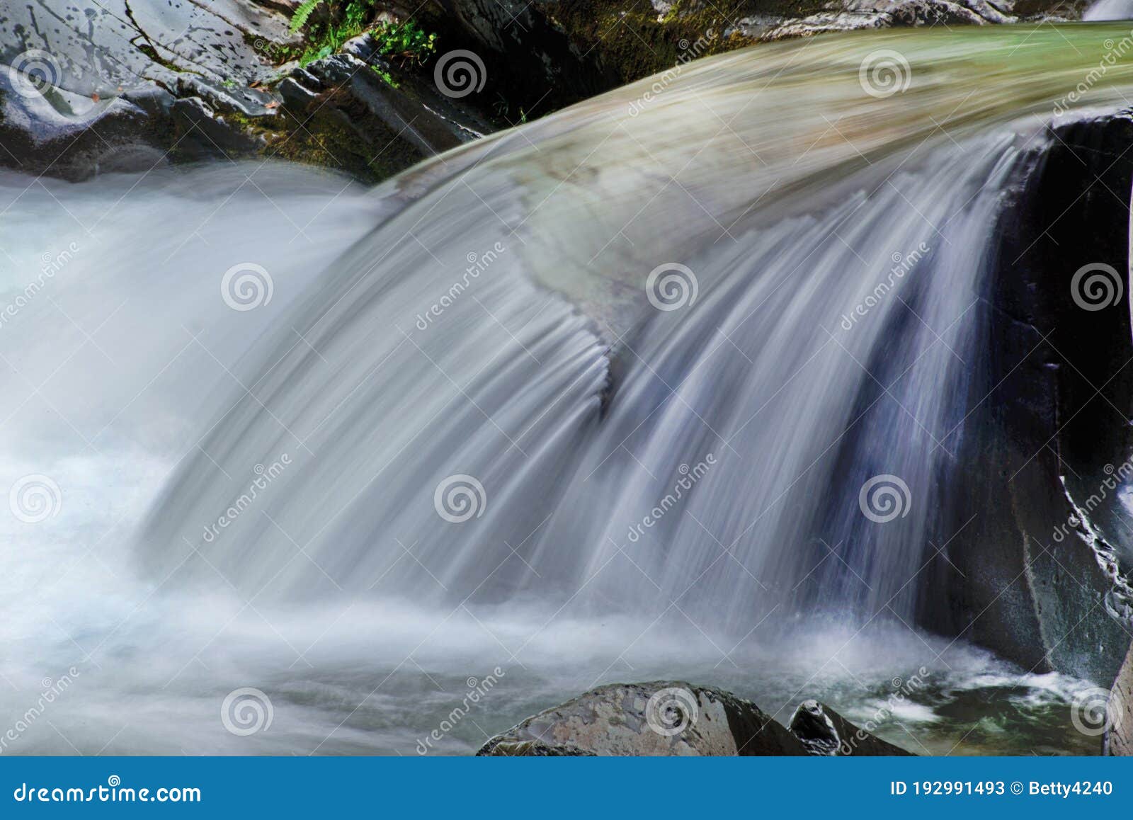 slow silky waters run over a boulder in the smokies.