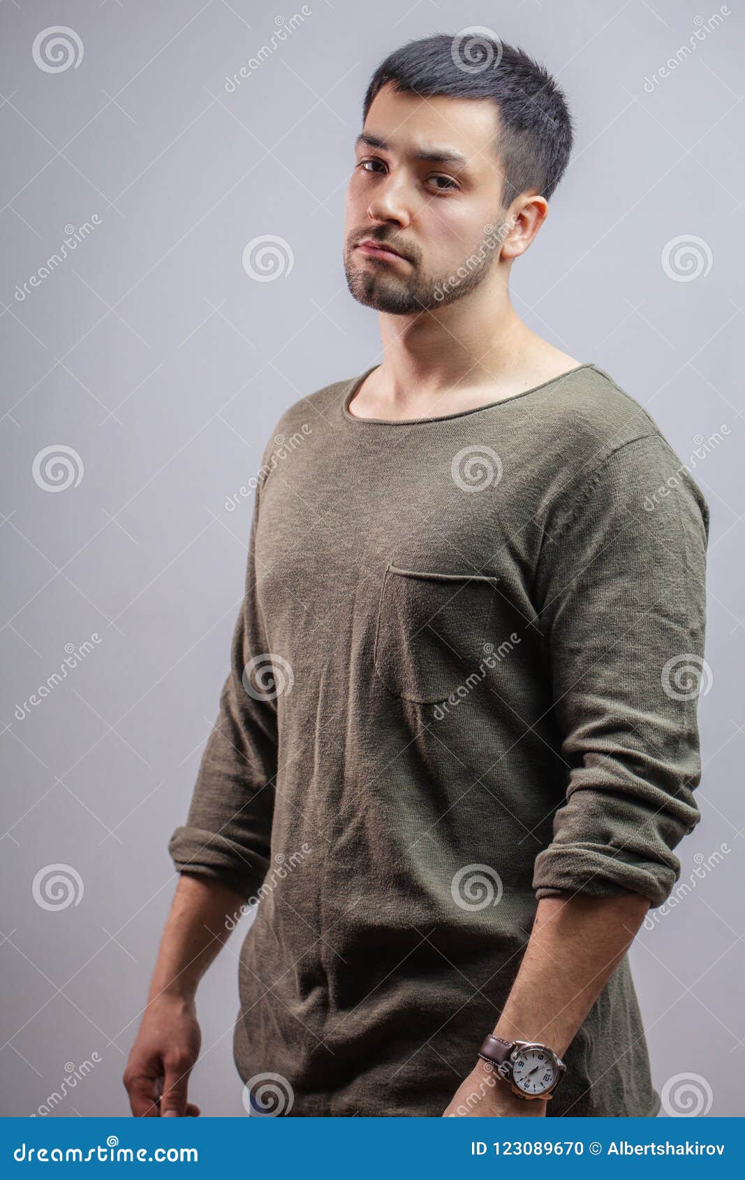 Sluit omhoog zijaanzichtportret van knappe jongen in grijs sweatshirt. Sluit omhoog zijaanzichtportret van een knappe jongen in grijs sweatshirt Het schot van de studio Het concept van de manier