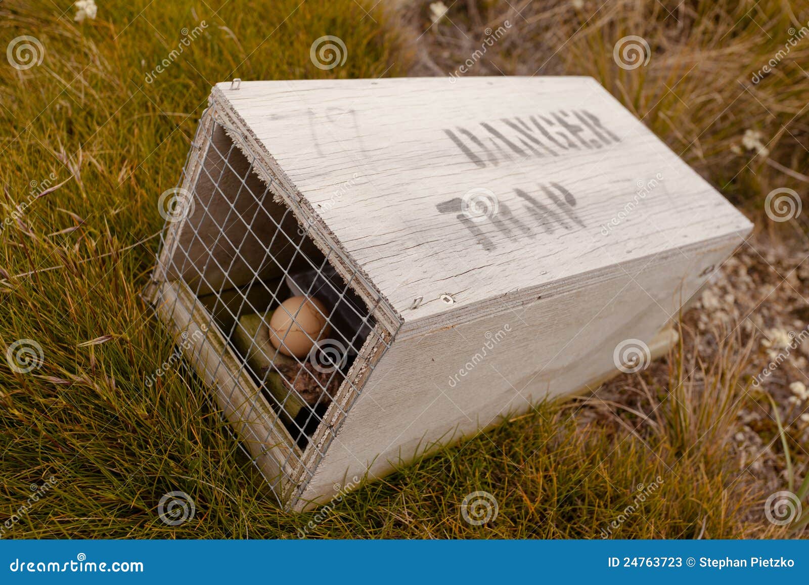 small animal trap with written warning for humans