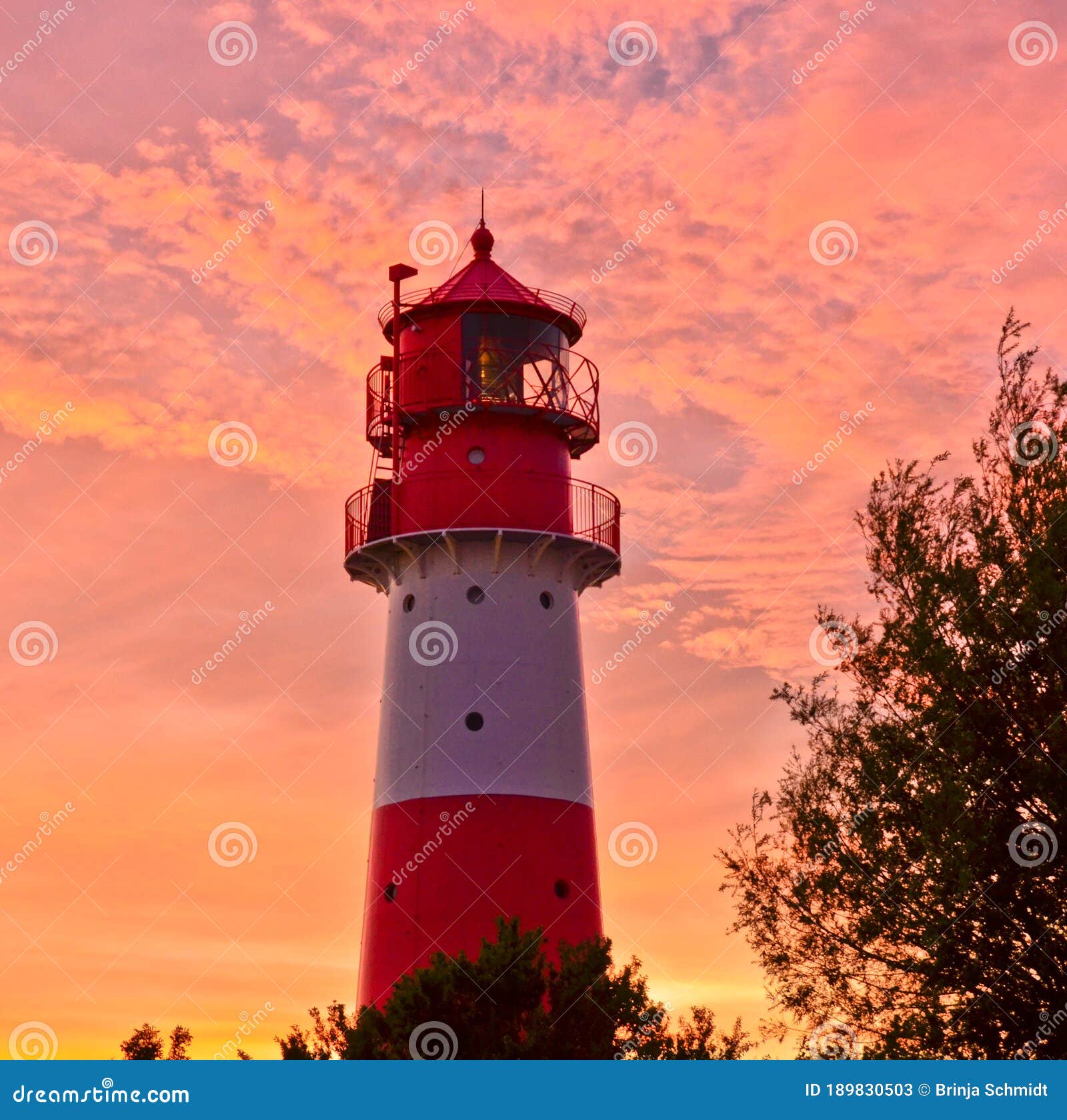 a small and beautiful lighthouse in the evening dawn sunset with pink clouds and bright light in falshÃÂ¶ft, germany