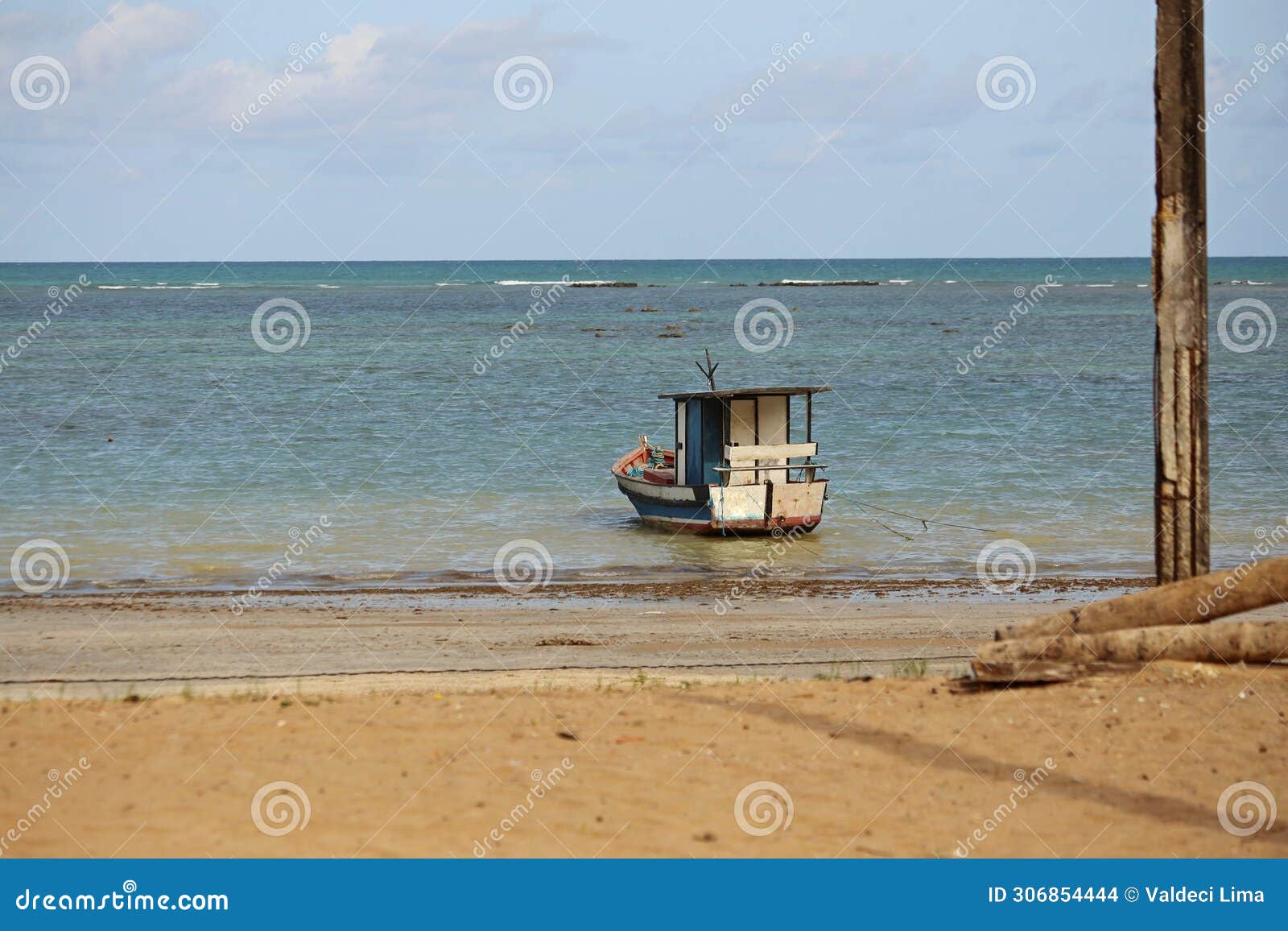 small boat anchored on beach water edge