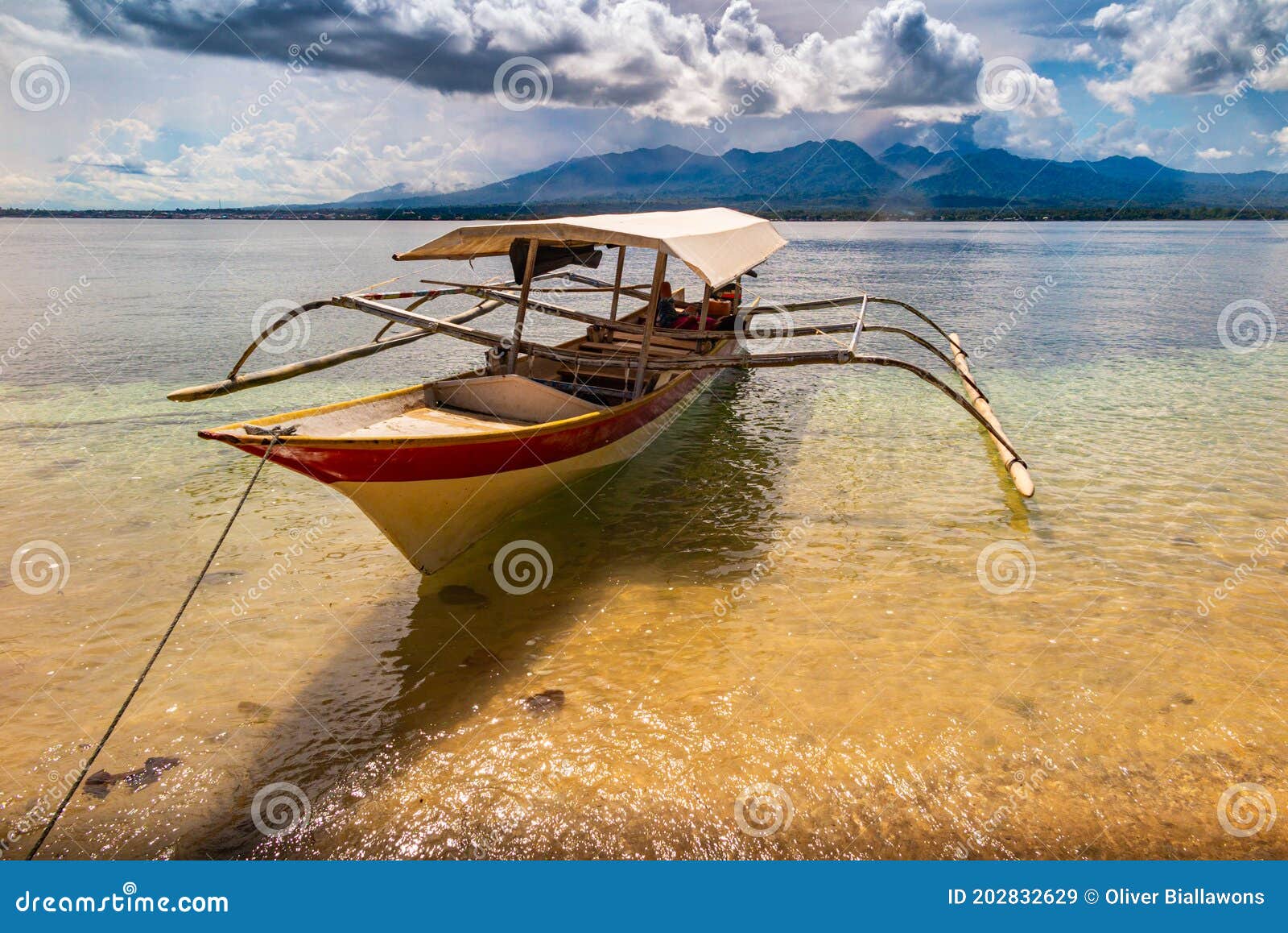 small boat on the green ocean with mountains in the background, maluku, indonesia