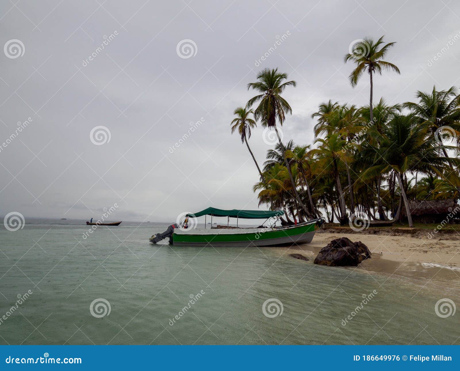 small boat next to a rock at isla pelicano, san blas panama