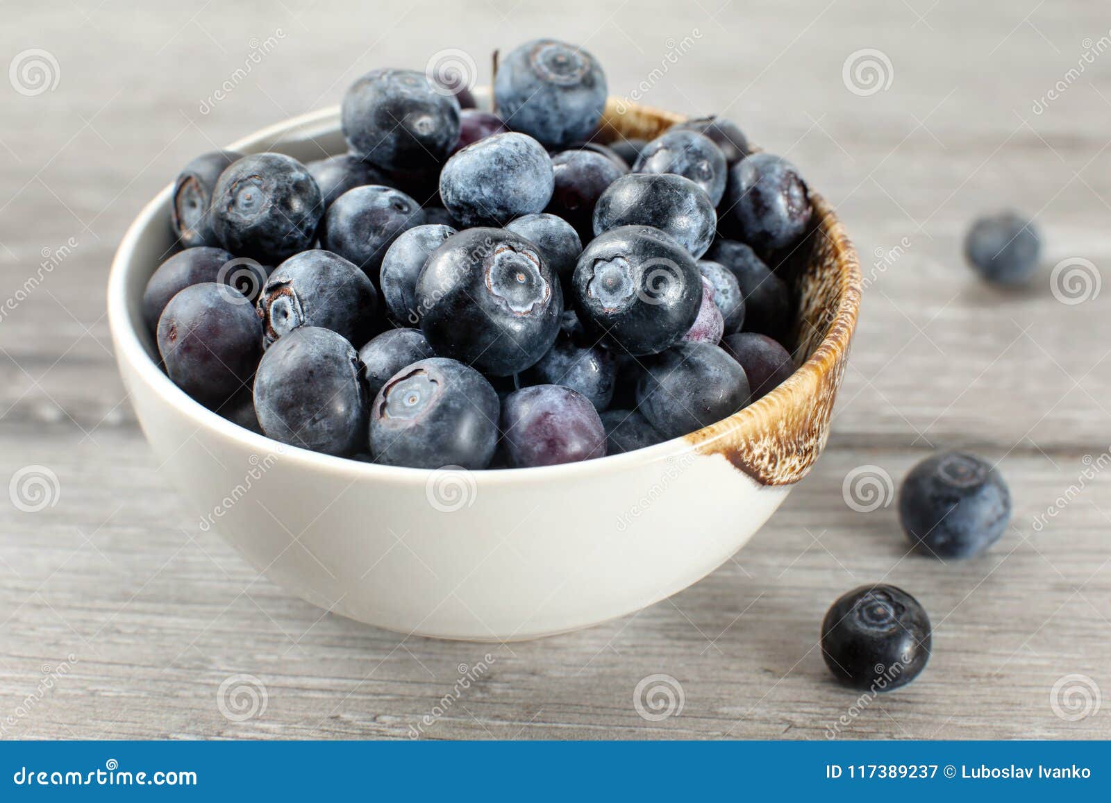 Small Bowl Full of Blueberries, Some of Them Spilled on Gray Woo Stock ...