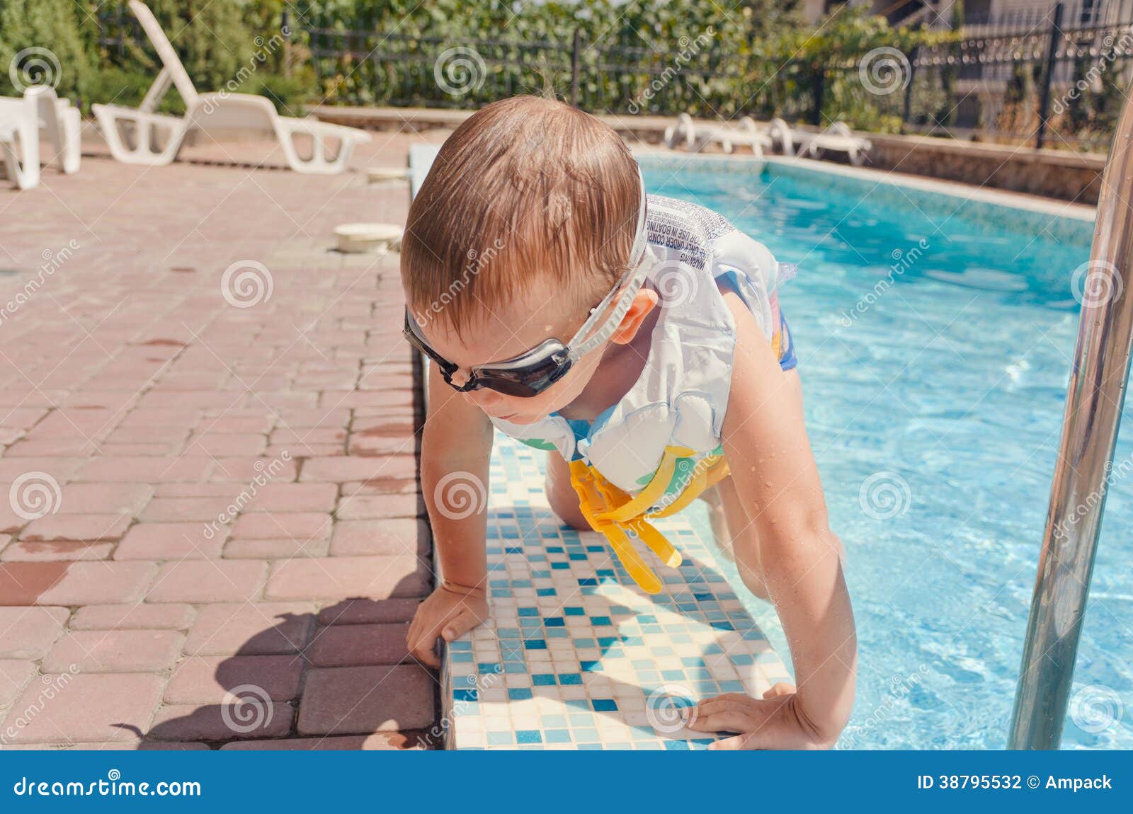 small boy clambering out of a swimming pool
